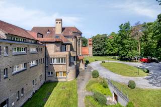 <p>Dit appartement met 2 slaapkamers en terras bevindt zich in een uitzonderlijk rustige en groene omgeving midden in het prachtige Kluisbos te Buizingen. De ligging combineert een unieke natuurlijke omgeving met een goede bereikbaarheid naar omliggende gemeenten en voorzieningen.</p><p>Het appartement bevindt zich op de tweede verdieping van een gebouw dat is uitgerust met een lift.</p><p>Via de inkomhal komt u in de leefruimte met living en eetplaats. Deze ruimte geniet van een aangename lichtinval en geeft rechtstreeks toegang tot het zuidwestgerichte terras. Het terras vormt een aangename plek om te genieten van de rust en de groene omgeving.</p><p>De keuken is praktisch ingedeeld met voldoende werk- en opbergruimte.</p><p>Verder beschikt het appartement over een aparte toilet, een wasplaats en een berging die zorgen voor extra praktisch comfort.</p><p>De badkamer is functioneel ingericht en vult het geheel aan.</p><p>Het appartement beschikt over twee ruime slaapkamers die flexibel kunnen worden ingericht volgens uw woonbehoeften.</p><p>Het appartement, is uitgerust met centrale verwarming op gas met een recente verwarmingsketel. Daarnaast is er dubbele beglazing en zijn er individuele tellers aanwezig.</p><p>De ligging vormt een belangrijke troef voor wie op zoek is naar rust en natuur. Tegelijk bevinden verschillende faciliteiten, winkels en verbindingswegen zich op korte afstand.</p><p>Dit appartement vormt een interessante woonopportuniteit voor wie wil wonen in een groene en rustige omgeving met een aangenaam terras en twee slaapkamers.</p><p></p><p>Indien u meer info / plaats bezoek wenst ,aarzel niet om ons te contacteren.</p><p>Stedenbouwkundige inlichtingen zijn aanwezig.</p><p></p><p></p>