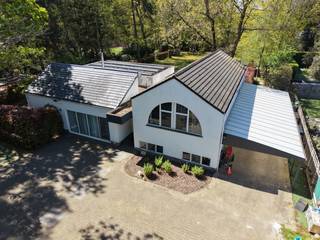 Aan de rand van het park Mikhof en op een boogscheut van het centrum van Sint-Job-in-'t-Goor, vinden we deze ruime karaktervolle villa terug op een perceel van 3.034 m2 met zwembad en een groot vergund bijgebouw. <br /><br />We betreden de woning via de ruime inkomhal die ons aan de linkerkant toegang geeft tot het leefgedeelte van de woning. Hier vinden we 2 ruime zitkamers terug , de eetruimte, een bureauruimte en een aparte ontbijthoek. Allemaal op een goed onderhouden parket.<br /><br />Dankzij de grote raampartijen geniet deze woning van een uitstekende lichtinval en creëert het een gevoel van rust door het groen rondom de woning. <br /><br />Aansluitend vinden we nog de volledig geïnstalleerde keuken (2000) terug voorzien van een kookplaat met dampkap, een ijskast met vriezer, een combi-oven, gewone oven, bordenwarmer en vaatwasser. Dankzij de lichtkoepel geniet ook de keuken van een goede lichtinval. <br /><br />Aan de rechterkant van de woning vinden we de slaapkamers en badkamers terug telkens op een half verdiep verschil. Met 6 treden naar boven vinden we de ruime master-bedroom terug van 22 m2. Daarnaast zijn er nog 2 slaapkamers, een berging en een badkamer met bad en douche terug te vinden. <br /><br />Een half verdiep lager vinden we nogmaals 3 ruime slaapkamers, een badkamer en een apart toilet terug. Deze kamers kunnen ook perfect gebruikt worden als bureauruimte of om een vrij beroep uit te oefenen. <br /><br />Wat deze woning extra uniek maakt is het grote én vergunde bijgebouw (2019) van maar lieft 180 m2 over de 2 verdiepen, voorzien van een leef -en eetruimte, een open keuken, een apart toilet, een badkamer met inloopdouche en 3 slaapkamers. Ideaal dus voor co-housing. <br /><br />Verder beschikt de woning nog over:<br /><br />- Een vergund zwembad van 24 m2<br />- Een perfecte zuid-west oriëntatie <br />- Een grote carport voor 3 auto's of meer <br />- Een zeer grote oprit waar meerdere auto's kunnen staan<br />- 15 zonnepanelen (2019)<br />- Een recente ketel (2019) <br />- Goede EPC score <br />- Conforme elektriciteit <br />- Badkamers op vloerverwarming <br />