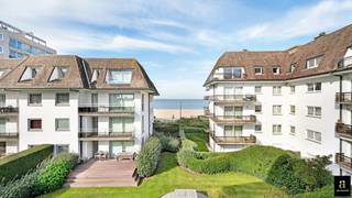 Schitterend instapklaar luxe-appartement met zeezicht, gelegen in een exclusieve villaresidentie in het Zoute. Indeling: inkomhal met vestiaire en gastentoilet. Lichtrijke woon- en eetkamer met elektrische haard. Open keuken uitgerust met hoogwaardige toestellen en een gezellige ontbijthoek. Zowel de leefruimte als de keuken geven uit op het ruime terras (30m²) met een adembenemend zicht op zee. Master bedroom met ingemaakte kasten en eigen douchekamer. Tweede volwaardige slaapkamer met bureau. Badkamer voorzien van dubbele lavabo, douche en apart toilet, evenals praktische ingemaakte kasten. Derde slaapkamer met bureau. Privatieve kelder en gemeenschappelijke fietsenberging aanwezig. Mogelijkheid tot aankoop van een dubbele garagebox (achter elkaar) in de residentie. Exclusief te koop.