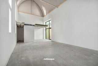 Het voormalige Karmelietessenklooster, één van de best bewaarde geheimen in het historische centrum van Brugge, krijgt dankzij een bijzondere herbestemming een nieuw leven. Het klooster wordt opgewaardeerd tot een klassevol woonproject waarin de oorspronkelijke erfgoedelementen zorgvuldig worden verweven met hedendaagse architectuur. Karmel omvat appartementen, woningen en één exclusieve kapelloft.<br /><br />De combinatie van dit historische kader met een privatieve tuin van maar liefst 5.000 m² maakt Karmel tot een uitzonderlijke plek om te wonen. Verscholen in het hart van Brugge geniet je hier van een bijzondere rust en privacy, op wandelafstand van alles wat de binnenstad te bieden heeft.<br /><br />De woning uit deze advertentie is zonder twijfel één van de blikvangers van het project: de unieke kapelloft. De oorspronkelijke neogotische kapel dateert uit 1877 en wordt gekenmerkt door haar zes traveeën, spitsboogvensters, spitsboognis en het indrukwekkende spitsbooggewelf met trekankers. Bij de herbestemming tot loft blijft het karakter en de ruimtelijkheid van de voormalige kapel maximaal behouden.<br /><br />De royale leefruimte vormt het hart van de loft en straalt dankzij de hoge gewelven en authentieke architectuur een uitzonderlijk gevoel van ruimte en klasse uit. Het grote raam ter hoogte van de keuken biedt een prachtig en open zicht op de uitgestrekte kloostertuin. Een draaitrap verbindt de leefruimte met een hoger gelegen bureauruimte, die uitkijkt over de loft.<br /><br />Op het gelijkvloers bevindt zich eveneens de master bedroom met aansluitende badkamer. Op de bovenverdieping zijn twee bijkomende slaapkamers en een tweede badkamer voorzien.<br /><br />De grootste werken zijn intussen achter de rug. Als koper krijg je nog de ruimte om de laatste afwerkingskeuzes zelf te maken en de kapelloft zo verder vorm te geven volgens je eigen stijl. De hoogwaardige basisafwerking omvat onder meer eiken parket, uitgeruste badkamers en een keuken met natuurstenen werkblad en toestellen. De laatste materiaal- en interieurkeuzes kan je als koper nog mee bepalen.<br /><br />Ook op het vlak van duurzaamheid en technisch wooncomfort werd Karmel toekomstgericht uitgewerkt. De kapelloft is bijzonder compleet uitgerust met geothermische verwarming en koeling, vloerverwarming, ventilatiesysteem D met warmterecuperatie, zonnepanelen en regenwaterrecuperatie.<br /><br />Karmel combineert zo een unieke historische locatie met rust, ruimte, klasse en modern wooncomfort, midden in het centrum van Brugge.<br /><br />Wil je deze bijzondere kapelloft en de site zelf ontdekken? Contacteer ons voor een bezoek ter plaatse via 050 45 03 45 of info@delbecque.immo.