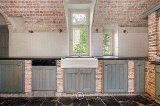 Deze karaktervolle woning in de Pieter Pourbusstraat biedt een verrassend ruime en veelzijdige indeling, verdeeld over verschillende niveaus. De woning combineert authentieke charme met aangename leefruimtes en beschikt over vier slaapkamers, twee badkamers, meerdere keukens en een terras langs het water.<br /><br />Via de inkomhal, met trap naar de bovenverdiepingen en een apart toilet, komt u in de eerste keuken. Vanuit deze ruimte leidt een kleine trap naar een gezellige woonruimte met twee ingebouwde kasten. Deze leefruimte staat bovendien rechtstreeks in verbinding met de inkomhal.<br /><br />Vanuit de keuken leidt de trap naar beneden naar een tweede keuken die aansluit op een praktische kelderruimte. Vanuit dit niveau is er toegang tot de binnenkoer en tot het terras langs het water, een bijzonder aangename plek om tot rust te komen.<br /><br />Op de eerste verdieping bevinden zich twee slaapkamers. Aan de linkerzijde ligt slaapkamer 1, die beschikt over een eigen badkamer. Verderop in de gang vindt u een apart toilet en een tweede badkamer. Aan het einde van de gang bevindt zich slaapkamer 2.<br /><br />De tweede verdieping beschikt over nog twee volledig afgewerkte slaapkamers. Daarnaast is er een ruime zolder, die extra bergruimte biedt.<br /><br />Deze woning is ideaal voor wie op zoek is naar een ruime en karaktervolle woning op een unieke locatie in Brugge, met verschillende leefruimtes en het bijzondere voordeel van een terras dat rechtstreeks aan het water gelegen is.<br /><br />Beschikbaar vanaf 01/12/2026<br />Extra maandelijkse kosten voor onderhoud: 50 euro