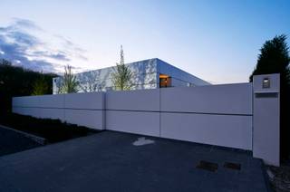 <strong>EXCLUSIEVE DESIGNWONING MET TIJDLOZE ARCHITECTUUR EN HIGH-END AFWERKING.<br /></strong><br />In Dilsen-Stokkem bevindt zich deze uitzonderlijke designwoning, een architecturale parel waarin minimalisme, technologie en wooncomfort naadloos samenkomen. Deze unieke residentie werd ontworpen als visitekaartje van PAS Interieurconcepten en ademt visie, vakmanschap en pure woonbeleving.<br /><br />De woning onderscheidt zich onmiddellijk door haar strakke en tijdloze architectuur. Aluminium cassettes, grote profielloze glaspartijen en een doorgedreven lijnenspel creëren een bijzonder esthetisch geheel waarbij binnen- en buitenruimte perfect in elkaar overvloeien. Elk detail werd doordacht uitgewerkt met oog voor functionaliteit, rust en verfijning.<br /><br />Binnen geniet u van een exclusief interieurconcept waarin technieken volledig geïntegreerd werden in het ontwerp. Keukentoestellen, deuren en opbergruimtes verdwijnen subtiel in maatwerk, waardoor een uiterst sereen en luxueus totaalbeeld ontstaat. De woning beschikt bovendien over innovatieve technieken zoals vloerverwarming gecombineerd met plafondpanelen voor zowel verwarming als koeling, een centraal stofzuigsysteem, uitgebreid domotica-systeem en een uitzonderlijk energiezuinig karakter.<br /><br />De indeling van de woning werd ontworpen met focus op comfort, lichtinval en praktische leefbaarheid. Via de stijlvolle inkomhal bereikt u het gastentoilet, de ruime leefruimte en de luxueuze leefkeuken, die samen het hart van de woning vormen. De master bedroom beschikt over een ensuite badkamer en biedt een oase van rust en privacy. Verder bevindt zich op het gelijkvloers nog een tweede slaapkamer met eigen badkamer en daarnaast een praktische wasplaats.<br /><br />In de kelderverdieping bevinden zich nog twee volwaardige slaapkamers, een polyvalente hobbyruimte of kantoorruimte en een technische ruimte.<br /><br />Ook buiten werd niets aan het toeval overgelaten. De prachtige zwemvijver en ingebouwde jacuzzi zorgen voor een unieke vakantiesfeer in eigen tuin, terwijl de vrijstaande garage van ca. 100m² tal van mogelijkheden biedt voor wagenliefhebbers, opslag of hobbyactiviteiten.<br />Dankzij de hoogwaardige isolatieschil en het vooruitstrevende ontwerp behaalt deze woning een indrukwekkend energiepeil, volledig afgestemd op hedendaags en toekomstgericht wonen.<br /><br />Deze eigendom is meer dan een woning — het is een totaalconcept waarin architectuur, interieur en techniek elkaar versterken tot een unieke woonervaring. Een zeldzame opportuniteit voor liefhebbers van design, luxe en compromisloos comfort.<br /><br />Interesse in deze exclusieve architectenwoning? Contacteer ons voor meer informatie of een persoonlijke rondleiding.