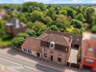 Een zee aan ruimte, volledig omringd door groen en toch midden in het centrum? Deze bijzondere eigendom aan de Weg naar Opoeteren 10-12 in Opglabbeek biedt een zeldzame combinatie van een centrale ligging, een uitgestrekt perceel van maar liefst 41 are (4.100 m²) en bijzonder veel mogelijkheden!<br /><br />Het geheel bestaat uit twee hoofdwoningen en vier aaneengesloten garageboxen die samen één ruim geheel vormen. De verschillende woonruimtes bieden heel wat flexibiliteit, zowel voor grote of samengestelde gezinnen als voor investeerders die op zoek zijn naar een opbrengsteigendom.<br /><br />Ook voor wie droomt van een kleinschalige B&B, een eigendom met ruimte voor dieren of paarden, een combinatie van wonen en werken of een toekomstig vastgoedproject, biedt dit uitzonderlijke perceel met de bijbouw (garages) interessante perspectieven, uiteraard onder voorbehoud van de nodige vergunningen en toepasselijke voorschriften.<br /><br />De absolute troef? Ondanks de ligging in het centrum geniet u hier van een verrassend groene omgeving, veel privacy en een uitgestrekt terrein. Een unieke combinatie die zelden voorkomt!<br /><br /><strong>Indeling: Woning nr. 10 – drie verdiepingen met verschillende woonruimtes</strong><br />De woning op nummer 10 strekt zich uit over drie verdiepingen en is momenteel feitelijk ingericht in drie afzonderlijke woonentiteiten, maar vormt stedenbouwkundig één woning.<br /><br />Elke verdieping beschikt over eigen leef- en zitruimtes, een keuken, badkamer, toilet en slaapkamers. Deze indeling biedt bijzonder veel flexibiliteit en mogelijkheden voor grote gezinnen, inwonende familieleden of een alternatieve invulling.<br /><br /><strong>Woning nr. 12 – ruime gezinswoning</strong><br />Op nummer 12 treffen we een ruime eengezinswoning, met onder meer een inkomhal, zit- en leefruimtes, slaapkamers, een keuken, badkamer, wasruimte en toilet.<br /><br />Deze opstelling biedt interessante mogelijkheden voor wie met meerdere generaties samen wil wonen, maar toch voldoende zelfstandigheid en privacy wenst te behouden.<br /><br /><strong>Buitenruimte en bijgebouwen</strong><br />Achter de hoofdgebouwen bevinden zich vier aaneengesloten garageboxen die samen één ruim geheel vormen. Deze ruimte biedt bijzonder veel mogelijkheden en kan niet alleen dienen als garage of opslagplaats, maar is ook interessant voor zelfstandigen en vrije beroepers die behoefte hebben aan extra werkruimte, een atelier of eventueel een praktijkruimte. Een gedeelte van de garage beschikt over een verdieping, dat ingericht kan worden als extra opslagruimte, hobbyruimte of kantoor.<br /><br />Verder beschikt de eigendom over een binnenkoer en een bijzonder ruime achtertuin. Het volledige perceel omvat maar liefst 4.100 m² grond en biedt daardoor uitzonderlijk veel buitenruimte.<br /><br />De groene omgeving en de omvang van het terrein maken deze eigendom extra aantrekkelijk voor liefhebbers van rust, natuur en buitenleven. Ook voor dierenliefhebbers die dromen van ruimte voor bijvoorbeeld paarden of andere dieren, kan het terrein interessante mogelijkheden bieden, afhankelijk van de bestemming, inrichting en geldende voorschriften.<br /><br /><strong>Technische informatie</strong><br />De eigendom beschikt over een EPC-label B met een energiescore van 195 kWh/m² per jaar, wat een belangrijke troef vormt op energetisch vlak.<br />Daarnaast zijn er zonnepanelen aanwezig op zowel de woning als de garage, die bijdragen aan de opwekking van hernieuwbare energie.<br /><br /><strong>Potentieel en ontwikkelingsmogelijkheden: bijzonder veel!</strong><br />Wat deze eigendom werkelijk uniek maakt, is de combinatie van de verschillende gebouwen, het uitzonderlijk ruime perceel en de centrale ligging.<br />Voor investeerders biedt de bestaande indeling interessante perspectieven voor verhuur en het creëren van huurinkomsten, rekening houdend met de vergunde toestand van de verschillende woonentiteiten of opsplitsbaarheid.<br /><br />Ook voor grote of samengestelde gezinnen is dit een bijzondere opportuniteit. Denk aan meerdere generaties die samen willen wonen, inwonende kinderen of familieleden die graag dicht bij elkaar blijven, maar toch over voldoende eigen ruimte beschikken. De gebouwen kunnen eventueel ook worden samengevoegd tot een groter woongeheel.<br /><br />Wie eerder droomt van een B&B, gastenverblijf of een kleinschalige toeristische activiteit, vindt hier eveneens een interessante basis. De verschillende gebouwen, de ruime buitenomgeving en de centrale ligging bieden mogelijkheden om wonen en gastvrijheid te combineren.<br /><br />Ook voor zelfstandigen en vrije beroepers biedt deze eigendom interessante perspectieven. De vier garageboxen vormen samen één ruime ruimte die zich uitstekend leent voor opslag, een atelier of andere professionele doeleinden. Ook een praktijkruimte of de combinatie van wonen en werken op dezelfde locatie behoort mogelijk tot de opties,<br /><br />Daarnaast kan het perceel aantrekkelijk zijn voor dieren- en paardenliefhebbers die op zoek zijn naar een eigendom met veel buitenruimte, midden in een groene omgeving.<br /><br />Ook voor projectontwikkelaars biedt deze eigendom potentieel. Het perceel is gelegen binnen het BPA Centrum, waardoor een eventuele herontwikkeling naar meerdere woongelegenheden of appartementen onderzocht kan worden.<br /><br />De mogelijkheden voor bijkomende woonentiteiten, toeristische activiteiten, professionele functies, het houden van paarden of een vastgoedontwikkeling zijn steeds afhankelijk van de geldende stedenbouwkundige voorschriften, de vergunde toestand en eventuele vereiste vergunningen. Voor concrete ontwikkelingsmogelijkheden kan voorafgaand advies worden ingewonnen bij de dienst Ruimtelijke Ordening van de gemeente Oudsbergen.<br /><br /><strong>Buurtinformatie</strong><br />Deze eigendom geniet van een uitzonderlijke ligging in het centrum van Opglabbeek, waar alle dagelijkse voorzieningen binnen handbereik liggen, terwijl u tegelijkertijd kunt genieten van een verrassend groene en rustige woonomgeving.<br />Winkels, supermarkten, scholen, banken, horecazaken, openbaar vervoer en andere voorzieningen bevinden zich in de directe omgeving. Hierdoor combineert u het gemak van centraal wonen met het comfort van een uitgestrekt privéterrein.<br /><br />Wat deze locatie zo bijzonder maakt, is het groene karakter van het perceel en de omliggende omgeving. Ondanks de centrumligging wordt de eigendom omgeven door groen, waardoor u kunt genieten van een gevoel van ruimte, privacy en rust dat doorgaans eerder met het buitengebied wordt geassocieerd.<br /><br />Ook de ruimere omgeving van Oudsbergen biedt tal van recreatiemogelijkheden, met uitgestrekte natuurgebieden, wandel- en fietsroutes en verschillende sportfaciliteiten. Bovendien zijn omliggende gemeenten zoals Genk, As, Bree en Maaseik vlot bereikbaar.<br /><br />Hier geniet u van het beste van twee werelden: alle voordelen van een centrumligging, gecombineerd met de ruimte en het groene karakter van een landelijk gelegen eigendom.<br /><br /><strong>Een zeldzame opportuniteit met toekomstperspectief!</strong><br />Of u nu op zoek bent naar een ruime gezinswoning, een eigendom voor meerdere generaties, een investeringspand, een mogelijke B&B, een plek voor dierenliefhebbers, een combinatie van wonen en werken of een ontwikkelingsproject: deze eigendom biedt een uitzonderlijke basis om uw plannen te realiseren.<br />Vooral de combinatie van meerdere gebouwen, een ruim garagecomplex, 41 are grond, een groene omgeving en een topligging in het centrum van Opglabbeek maakt dit een bijzonder veelzijdig vastgoedaanbod.<br /><br />Wenst u het potentieel van deze unieke eigendom zelf te ontdekken? Contacteer ons via 089 69 30 01 of info@consimmo.be voor meer informatie of een bezoek ter plaatse.