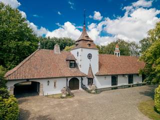 Deze uitzonderlijke villa bevindt zich op een steenworp van de Grote Markt van Roeselare (slechts 2,5 km in vogelvlucht) en heeft een vlotte verbinding naar de E403. Voor wie op zoek is naar ruimte, groen, rust en veel karakter is dit een uitgelezen kans.Deze exclusieve eigendom op ca. 1ha omvat een statige villa in kasteelhoevestijl (bouwjaar 1976), een afzonderlijke conciërgewoning (ca. 201 m² bewoonbare oppervlakte) en bijgebouwen. De villa beschikt over een royale bewoonbare oppervlakte van 683 m² en straalt een landelijke elegantie uit die onmiddellijk charmeert.Architecturale elegantie met romantische flair:witte gevels, sierlijke dakruiters, boogvormige doorgangen, smeedijzeren ornamenten, een massieve houten inkomdeur en karaktervolle loodglasramen zorgen voor een authentieke uitstraling met grandeur. De centrale toren fungeert als architecturale blikvanger.Binnenin biedt de woning onder meer:een imposante inkomhal met lange gang | riante woonkamer met zicht op de parktuin | een bureauruimte en slaapkamers op het gelijkvloers | een keuken met aansluitende bijkeuken | gelijkvloerse badkamer en solarium | meerdere (slaap)kamers op de verdieping| een wijnkelder en dubbele garage...Buitenleven in een parktuin met vijverDe leefruimtes kijken uit op de grote vijver en het omliggende parkdomein, wat zorgt voor een permanent vakantiegevoel. De binnenkoer, omsloten door de gebouwen, tuinmuur en toegangspoort, biedt absolute privacy en een bijzondere sfeervolle beleving.Veelzijdigheid en potentieelHet domein is opsplitsbaar; aankoop met meer of minder grond is bespreekbaar. Daarnaast grenzen meerdere ruime percelen bouwgrond (recent verkaveld) aan het geheel, die afzonderlijk beschikbaar zijn bij aparte verkoop.Een eigendom met zielDe aanwezigheid van eeuwenoude antieke bouwkundige sierelementen verleent deze villa een uitzonderlijke uitstraling. Een unieke eigendom met talloze invulmogelijkheden.Contacteer ons voor meer info of een bezoek. Dit domein moet u ter plaatse ervaren.