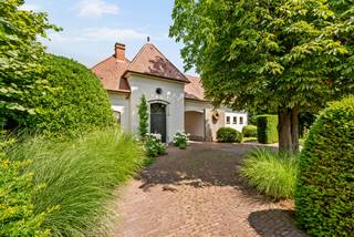 Cette villa élégante est située au calme à Voortkapel (Westerlo) et allie espace, confort et finitions de haute qualité. La maison dispose d'un salon lumineux avec coin salon confortable, salle à manger et une cuisine entièrement équipée, une buanderie pratique, 3 à 4 chambres, un dressing, une salle de bains spacieuse et un garage ouvert pouvant accueillir 2 voitures. À l'extérieur, vous pourrez profiter d'un jardin magnifiquement aménagé et entièrement clôturé avec piscine chauffée et charmant poolhouse.<br /><br />Rez-de-chaussée :<br />Vous entrez dans la maison par le hall d'entrée spacieux. Le salon bénéficie d'une abondance de lumière naturelle grâce aux grandes baies vitrées et forme, avec la cuisine ouverte, le cœur de la maison. La cuisine moderne est entièrement équipée avec des appareils de qualité, dont un four, un tiroir chauffant, une plaque de cuisson à induction, une hotte, une machine à café, un lave-vaisselle et un réfrigérateur. À côté se trouvent un débarras pratique et une buanderie avec des raccordements pour machine à laver. Il y a également un espace bureau au rez-de-chaussée, actuellement aménagé en 4ème chambre. À l'arrière de la maison se trouve une agréable orangerie, un endroit idéal pour se détendre en famille et entre amis. Le bar présent rend cet espace parfait pour recevoir des invités.<br /><br />Premier étage :<br />Par l'escalier dans le hall d'entrée, vous accédez au premier étage. Le palier donne accès à trois grandes chambres. La chambre principale dispose d'un dressing attenant. Il y a également une salle de bains entièrement équipée avec double vasque, douche à l'italienne, baignoire et toilettes.<br /><br />Jardin :<br />Le jardin magnifiquement aménagé et entièrement clôturé offre une intimité optimale et une vue verdoyante agréable. La piscine chauffée avec poolhouse est sans aucun doute un atout majeur de cette maison. Grâce à la végétation mature, vous pourrez profiter de calme, d'ambiance et de détente toute l'année.<br /><br />Caractéristiques :<br />* Climatisation dans les chambres<br />* Piscine chauffée avec poolhouse<br />* Sans amiante<br />* Conforme aux normes électriques<br />* Entièrement clôturé<br />* Jardin magnifiquement aménagé et mature