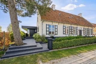Dit uitzonderlijke eigendom is gelegen op een prachtig perceel van ca. 3.000 m² en combineert de charme van een authentieke hoeve met de elegantie van een moderne, architecturaal geïntegreerde aanbouw. Het resultaat is een lichtrijke, warme en uiterst karaktervolle woning die uitblinkt in klasse en comfort.<br /><br />Indeling & leefruimtes<br /><br />Bij het betreden van de woning komt u via de inkomhal met vestiaire in de royale leefruimte met grote glaspartijen, die een overvloed aan natuurlijk licht binnenlaten en rechtstreeks toegang geven tot het ruime, deels overdekte terras. Hier geniet u van een panoramisch open zicht op de groene omgeving.<br /><br />De volledig ingerichte leefkeuken, afgewerkt met kwalitatieve materialen, is een echte blikvanger en biedt aansluitend een praktische bijkeuken met voorzieningen voor het plaatsen van een wasmachine en droogkast.<br /><br />Slaapkamers & badkamers<br /><br />De master bedroom beschikt over veel ingemaakte kasten en een prachtig open uitzicht, met aansluitend een ruime badkamer. Daarnaast vindt u op het gelijkvloers nog een tweede volwaardige slaapkamer met ingemaakte kasten, een gezellige tv-kamer/bureau en een multifunctionele kelderruimte.<br /><br />Op de verdieping bevinden zich drie bijkomende ruime slaapkamers, een apart toilet en een badkamer.<br />Buitenruimte & extra’s<br />Een absolute troef van dit eigendom is het verwarmde buitenzwembad van ca. 17,5 m lang – perfect geïntegreerd in de tuin en afgewerkt met hoogwaardige materialen. De royale oprit geeft toegang tot de zeer ruime inpandige garage.<br />Verder geniet deze woning van talrijke extra’s die bijdragen aan het ultieme wooncomfort:<br />Twee open haarden<br />Domoticasysteem<br />Alarmsysteem en camerabewaking<br />Gedeeltelijke vloerverwarming<br />Ruime oprit met veel autostaanplaatsen buiten de garage<br /><br />Een exclusieve woning die authenticiteit en modern comfort moeiteloos combineert. Dankzij de lichtrijke ruimtes, hoogwaardige afwerking, het adembenemende uitzicht en het unieke zwembad is dit een eigendom dat garant staat voor een uitzonderlijke woonervaring.