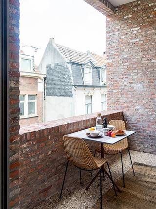 In de schaduw van het Gravensteen vinden dit prachtig gebouw, vol authentieke elementen. Het appartement is gelegen op de eerste verdieping en is uitgerust met een lichtrijke leefruimte en eetplaats. Zalig vertoeven met de koffie 's morgens op het terras. De keuken werd volledig uitgerust met alle toestellen. Verder is er een ruime slaapkamer met dressing en ensuite badkamer met lavabo en inloopdouche. Apart toilet. Het appartement werd stijlvol ingericht met kwalitatieve meubels. Verhuur mogelijk voor korte termijn (minimum 6 maanden). Huurprijs 1.650 euro + 350 euro kosten (verbruik EGW, brandverzekering, internet, gemeenschappelijke kosten gebouw). Onmiddellijk beschikbaar