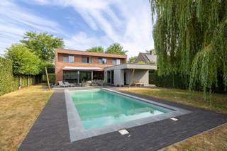 Deze moderne villa met 4slk en 2bdk, ruim zwembad en grote garage op een groen perceel van 1.282m² gelegen in een doodlopende straat op een steenworp van het bruisende centrum van Hoogstraten, scholen, Horeca, ontspanning en sport.<br /><br />Indeling:<br />Gelijkvloers:<br />- Inkomhal met vestiairekast en gastentoilet<br />- Zeer ruime woonkamer met eetkamer<br />- Open luxe leefkeuken<br />- Berging<br />- Badkamer vlak aan de achterdeur/zwembad<br /><br />Verdieping:<br />- 4 slaapkamers met toegang tot een terras<br />- Badkamer<br />- Berging<br />- Nachthal<br /><br />Dubbele garage met dubbele carport achteraan het perceel<br /><br />Bijzonderheden:<br />- Zwembad 13x5m met elektrische roldek<br />- Massieve parket- en natuurstenen vloeren<br />- 2022: 5460Wp zonnepanelen met batterij van 10kwp<br />- Achterbouw is nadien aangebouwd