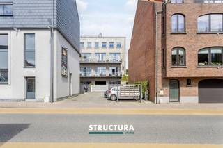 In het centrum van Merchtem bevindt zich deze ruime loft met een bewoonbare oppervlakte van ca. 133 m², ondergebracht in de voormalige Azijnbrouwerij. Het industriële karakter van het gebouw is mooi bewaard gebleven en komt onder meer tot uiting in de hoge plafonds, de authentieke plafondstructuur en de grote raampartijen.De leefruimte vormt het hart van de loft en combineert een open karakter met veel natuurlijke lichtinval. De gashaard zorgt voor extra sfeer en sluit mooi aan bij de industriële uitstraling van het geheel. Met drie slaapkamers, een EPC-label B en een centrale ligging biedt deze loft bovendien een interessante combinatie van ruimte, karakter en energiezuinigheid.IndelingEerste verdieping: Inkomhal met apart toilet, ruime en lichtrijke leefruimte, open keuken, terras, drie slaapkamers, douchekamer en badkamer met zowel bad als douche. Gelijkvloers: garage, bij aan te kopen aan €25.000 Karakteristieken- EPC-label B- Momenteel verhuurd aan € 1.175/maand- Centrale ligging in Merchtem- Zuid georiënteerd terrasEen karaktervolle loft waar de geschiedenis van het gebouw nog duidelijk voelbaar is, gecombineerd met een ruime indeling en hedendaags wooncomfort. Dankzij de drie slaapkamers, de oppervlakte van ca. 133 m² en het gunstige EPC-label B is dit een interessante eigendom voor wie op zoek is naar een ruime loft in het centrum van Merchtem. Contacteer ons via 02 460 80 46 of info@structura.be