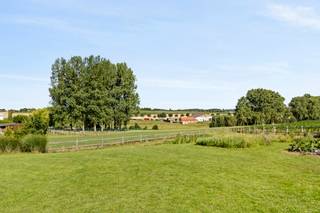 Unieke eigendom op 3.000 m² met 6 slaapkamers waarvan 2 met dressing, 2 badkamers, bureauruimtes en volledig onderkelderd (2,6 m hoog). Ingerichte keuken, vloerverwarming via warmtepomp, zonnepanelen (7.000 kWh), regenwateropvang (70.000 L met UV-filter). Dubbele garage, overdekt terras, aangelegde tuin met waterpartij, 2 paardenboxen. 2 laadpunten, B&amp;B- of kangoeroewoning mogelijk.