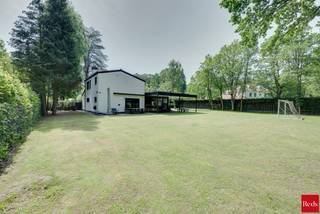 <p><strong>Gerenoveerde woning op een perceel van 2.000 m² in een residentiele woonwijk</strong></p>
<p>Deze recent volledig gerenoveerde woning combineert moderne architectuur, hoogwaardige afwerking en uitzonderlijk veel ruimte, zowel binnen als buiten. Gelegen op een perceel van maar liefst 2.000 m², geniet u hier van rust, privacy en zon gedurende de hele dag.</p>
<p>Bij het betreden van de woning komt u meteen de stijlvolle inkomhal met ingebouwde vestiairekasten en een gastentoilet. Dankzij de grote glazen deuren en wanden krijgt u meteen een prachtig zicht op de grote leefruimte.</p>
<p>De moderne open keuken vormt het hart van de woning en is volledig uitgerust met kwalitatieve toestellen van Bosch: een ingebouwde koffiemachine, combi-oven, extra oven, koelkast, diepvriezer en vaatwasser. Het ruime kookeiland en de Novy-inductiekookplaat met geïntegreerde dampkap maken deze keuken zowel praktisch als luxueus.</p>
<p>Aansluitend bevindt zich een ruime bijkeuken met extra bergruimte en aansluiting voor wasmachine en droogkast.</p>
<p>De royale leef- en eetruimte straalt licht en ruimte uit dankzij de grote raampartijen. Twee gezellige zithoeken worden subtiel van elkaar gescheiden door een moderne glazen wand, wat zorgt voor een open maar stijlvolle indeling. De gashaard maakt de zithoek extra gezellig.</p>
<p>Vanuit de leefruimte geven de grote schuiframen directe toegang tot de enorme tuin, waar u de hele dag door geniet van zon en groen. Op het gelijkvloers bevindt zich bovendien een kamer grenzend aan de leefruimte. Ideaal als bureau of extra slaapkamer.</p>
<p>Verder is er op het gelijkvloers nog een extra praktische dressingruimte. Via de stijlvolle spiltrap bereikt u de bovenverdieping, waar zich nog drie slaapkamers en een luxueuze badkamer bevinden.</p>
<p>De badkamer is afgewerkt in marmerlook en beschikt over een ruime inloopdouche, dubbele lavabo en toilet.</p>
<p>Extra troeven:<br />✔ Volledig gerenoveerd<br />✔ Perceel van ca 2.000 m²<br />✔ Ventilatiesysteem<br />✔ Overal zonnescreens<br />✔ Hoogwaardige materialen en moderne afwerking<br />✔ Gerenoveerd en instapklaar</p>
<p>Een instapklare woning voor wie op zoek is naar ruimte, luxe en comfort in een aangename omgeving.<br /><br />Voor meer informatie, contacteer Ellen via 0474/84.54.29 of ellen@reds.be</p>