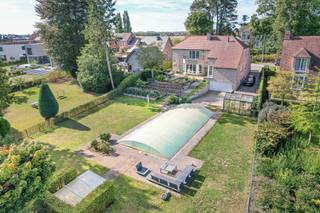 Deze villa op een perceel van ca. 1.900 m² weet je meteen te bekoren met haar ruimte, licht en adembenemend uitzicht over de omliggende velden. Met een bruikbare vloeroppervlakte van ca. 349 m² combineert de woning een warme sfeer met veel lichtinval en een praktische indeling die je alle comfort biedt.<br /><br />Bij het binnenkomen word je verwelkomd in een royale inkomhal die leidt naar een lichtrijk kantoor en een gezellige leefruimte waar grote raampartijen het zonlicht rijkelijk binnenlaten. De leefruimte sluit aan op de volledig ingerichte keuken, met zicht op de zuidgerichte tuin en het ruime terras. Op het gelijkvloers vind je daarnaast nog twee slaapkamers en een badkamer, wat zorgt voor een aangenaam wooncomfort op één niveau.<br /><br />Op de eerste verdieping wachten drie royale slaapkamers, een tweede badkamer en een multifunctionele ruimte met kitchenette. Een handige zolderruimte vervolledigt dit verdiep. Bovendien is de woning volledig onderkelderd en uitgerust met een lift die je vlot toegang geeft tot alle niveaus.<br /><br />De prachtige tuin is een oase van rust, zuidgericht en omgeven door groen, met een magnifiek verzicht dat je elke dag opnieuw doet genieten van de omgeving. Dankzij de aanwezigheid van zonnepanelen beschikt de woning over een energiezuinig label A.<br /><br />De ligging in Hombeek is bijzonder aantrekkelijk: vlak bij Mechelen en met vlotte verbindingen richting Brussel en Antwerpen. Je woont hier dicht bij winkels en voorzieningen, terwijl de landelijke omgeving de perfecte uitvalsbasis vormt voor heerlijke wandel- en fietstochten.<br /><br />Teaser: Een lichtrijke villa met ruimte, karakter en een tuin die uitmondt in een prachtig verzicht over de velden. Geniet hier van rust, licht en een uitzonderlijke ligging in Hombeek.