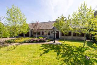 <p>In een groene en uiterst rustige omgeving in Mol, op een <strong>prachtig perceel van 3.010 m²</strong>, bevindt zich dit <strong>zeer ruime landhuis</strong>, opgetrokken met <strong>kwalitatieve materialen</strong>.</p>
<p>Via de ruime inkomhal met gastentoilet kom je in de aangename <strong>leefruimte van meer dan 50 m²,</strong> praktisch ingedeeld in een zithoek met inbouwcassette/open haard en een eethoek. Aansluitend is er een <strong>veranda</strong> die zorgt voor extra lichtinval en een mooi contact met de tuin.</p>
<p>De <strong>keuken</strong> sluit aan op de leefruimte en is uitgerust met onder andere een elektrische kookplaat, vaatwasser en koelkast. Het <strong>granieten werkblad</strong> benadrukt de degelijke afwerking. Op het <strong>gelijkvloers</strong> vind je verder een nachthal met toegang tot <strong>3 ruime slaapkamers</strong> en een extra kamer, ideaal als bureau, <strong>hobbyruimte of 4e slaapkamer</strong>. Daarnaast is er een badkamer met ligbad en toilet, evenals een <strong>dubbele inpandige garage</strong>. De totale bewoonbare oppervlakte van het gelijkvloers bedraagt <strong>ca. 250 m².</strong></p>
<p>Een absolute troef is de <strong>volledig onderkelderde verdieping van ca. 288 m².</strong> Deze is bereikbaar <strong>via 2 vaste trappen</strong>, zowel vanuit het woongedeelte als achteraan via de garage, en beschikt bovendien over <strong>een aparte inkomdeur met inkomhal</strong>. De <strong>garagepoort aan de achterzijde</strong> is bijzonder praktisch om met tuinmateriaal, fietsen of een grasmaaier rechtstreeks de tuin te bereiken.</p>
<p>Deze benedenverdieping is deels ingericht als bruikbare woon-/leefruimte. Zo zijn er momenteel onder meer een <strong>ruime wasplaats</strong>, <strong>2 extra kamers, een ruime hobbykamer en een 2e badkamer met sauna, inloopdouche, wastafel en toilet</strong>. Daarnaast zijn er nog meerdere voorraadkelders, ideaal voor stockage.</p>
<p>Ook de <strong>zolderverdieping</strong>, bereikbaar <strong>via een vaste trap, biedt met ca. 194 m² </strong>nog heel wat <strong>uitbreidingsmogelijkheden</strong> voor extra kamers, een speelruimte, hobbyruimte of thuiskantoor, afhankelijk van de technische haalbaarheid en gewenste invulling.</p>
<p>Rondom de woning ligt een enorm, groen en zeer goed onderhouden tuinperceel waar je in alle rust en privacy kan genieten. Extra troef is de ruime <strong>straatbreedte van ca. 38 meter</strong>, wat zorgt voor een mooie, open inplanting. Er is bovendien ruim <strong>voldoende parkeergelegenheid</strong> aan en rond de woning.</p>
<p>De woning beschikt over tal van hedendaagse comfort- en energietroeven, waaronder <strong>vloerverwarming, zonnepanelen, airco, sproei-installatie in de tuin, sauna, een gunstige EPC-score met label B en een asbestveilig attest.</strong></p>
<p><strong><em><u>Kortom</u>: dit uitzonderlijk ruime landhuis biedt mogelijkheden voor maar liefst <u>3 woonentiteiten</u> en is daardoor ideaal voor <u>kangoeroewonen</u>, een groot gezin of <u>zelfstandigen</u> die bijvoorbeeld een kine- of dokterspraktijk aan huis wensen. Een uniek eigendom; aan de snelle beslissers! </em></strong></p>