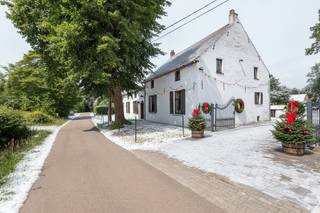The original farm with stables (1880) has been renovated into the current long farmstead. Many authentic elements have been preserved. Located along a street that leads to the fields, this is an ideal child-friendly location. You can enjoy the perfect balance between privacy and accessibility, with the city center, shops, schools, and public transport less than 4 km away.<br /><br />We enter the house through the huge entrance. The stables and feed troughs have been transformed into a living and dining area. The open space up to the roof ridge provides a lot of natural light. On the right side, the spaces have been preserved, creating 2 lounges and 2 dining areas.<br /><br />The first floor, accessible from two sides, includes several spacious bedrooms, a multipurpose room, and a bathroom. The spacious landing with a library and multiple seating areas is special. There is a connection to the ground floor through the huge loft, which also provides a lot of natural light.<br /><br />Layout:<br />Ground floor: entrance hall with bathroom, on one side a first dining and seating area with stairs to the first floor. On the other side, to the right, the kitchen with a second staircase, a small room, a second dining area, and a second seating area. The outdoor storage is accessible via the covered terrace, where the oil burner and above-ground tanks are located. On the first floor, a landing with loft, hallway with bathroom and a bedroom, multipurpose room with 3 bedrooms, and the second staircase downstairs.<br /><br />Details:<br />-underfloor heating in the living room<br />-central heating with oil (after 2000)