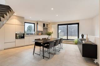 Op zoek naar een woning in Zwijnaarde dan is deze beletagewoning met een doordachte indeling en een uitgesproken architecturaal karakter absoluut uw bezoek waard.Op het gelijkvloers bevinden zich twee volwaardige slaapkamers, ideaal als master bedroom, kinderkamer, bureau of hobbyruimte. Dankzij de praktische indeling geniet deze verdieping van rust en functionaliteit.De eerste verdieping vormt het kloppend hart van de woning. Hier bevindt zich de volledig geïnstalleerde keuken, uitgerust met alle hedendaagse comfort. De keuken paalt rechtstreeks aan het ruime terras en creëert zo een perfecte binnen-buitenbeleving. Dit is dé plek om te koken, te tafelen en gasten te ontvangen.Op de tweede verdieping bevindt zich de royale leefruimte. Deze geniet van uitzonderlijk veel privacy en biedt een aangenaam zicht op het omliggende groen. De grote raampartijen zorgen voor een overvloed aan natuurlijk licht en versterken het open gevoel.De betonnen trappen vormen een echte blikvanger in de woning en zorgen voor een stoer, modern loftgevoel dat perfect aansluit bij de architecturale uitstraling.De woning heeft een mobiscore van 8,3 euro is het pand ideaal gelegen. Het pand ligt andere nabij van het Technologiepark en Tech Lane Ghent EilandINDELING: - Gelijkvloerse verdieping: Inkomhal met gastentoilet, berging, 2 slaapkamers, badkamer, koer en buitenberging- Eerste verdieping: Leefkeuken en ruim terras- Tweede verdieping: Woonkamer