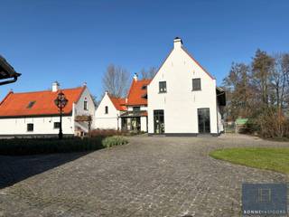 <p>Grens Damme-Brugge : in een uitzonderlijk rustige en groene omgeving, midden in het open polderlandschap, bieden wij u deze prachtige en veelzijdige eigendom aan. Een zeldzame kans voor wie op zoek is naar ruimte, natuur, privacy én karakter, op een strategische ligging tussen Brugge en Damme, vlak bij de Damse Vaart en het gekende paardenpension De Blauwe Zaal.</p>
<p>Het domein omvat een karaktervolle hoofdwoning, een volwaardige aparte woonst, een gerenoveerde schuur met stallen en een aangenaam poolhouse. Omringd door uitgestrekte weilanden en groen geniet u hier van absolute rust en volledige privacy. Dankzij de aanwezige stallen en weides is deze eigendom uitermate geschikt voor het houden van paarden, schapen, herten of andere dieren, maar ook voor wie simpelweg wil genieten van het buitenleven in alle vrijheid.</p>
<p></p>
<p>De hoofdwoning</p>
<p>Bij het betreden van de woning komt u in een charmante inkomhal die toegang geeft tot de sfeervolle eetkamer. Deze ruimte ademt authenticiteit dankzij de zichtbare houten balken, de rustieke vloer en het haardvuur. Dankzij het aanwezige gastentoilet is deze ruimte ook perfect inzetbaar als gezellige feest- of ontvangstruimte.</p>
<p>Aansluitend bevindt zich de keuken, met een prachtig uitzicht op het omliggende groen. Naast de keuken ligt de charmante voutekamer, een bijzonder aangename leefruimte waar u volledig tot rust komt terwijl u uitkijkt over de tuin en het open landschap.</p>
<p>Op de bovenverdieping bevinden zich vier slaapkamers. Eén kamer springt meteen in het oog door de indrukwekkende originele gebintes, die het landelijke karakter extra benadrukken. Twee andere slaapkamers beschikken over een eigen mezzanine, ideaal als speelse slaaphoek, bureau of extra bergruimte. Verder is er op deze verdieping ook een badkamer aanwezig.</p>
<p>Aparte woonst / bijgebouw</p>
<p>Aansluitend aan de hoofdwoning bevindt zich een volwaardige aparte woonunit, ingericht als zelfstandige woning. Deze beschikt over een gezellige leefruimte, een volledig uitgeruste keuken en één tot twee slaapkamers, elk met een eigen badkamer voorzien van douche en lavabo.</p>
<p>Deze wooneenheid biedt tal van mogelijkheden: kangoeroewonen, gastenverblijf, praktijk- of kantoorruimte, of zelfs verhuur.</p>
<p>Schuur en stallen</p>
<p>De indrukwekkende schuur (42,5mx10,5m) biedt een waaier aan mogelijkheden. Ze is ingedeeld in meerdere ruime zones, beschikt over een aparte kitchenette en boven de stallen bevindt zich een uitgestrekte open ruimte over de volledige breedte van het gebouw. De zichtbare originele gebintes zorgen voor een authentieke, landelijke uitstraling.</p>
<p>Ideaal als opslagruimte, atelier, hobbyruimte of voor verdere ontwikkeling. De schuur werd volledig gerenoveerd, met een nieuwe draagvloer en met respect voor alle originele elementen.<br /><br />Buitenruimte</p>
<p>De prachtig aangelegde tuin met vijver en poolhouse vormt een harmonieuze overgang naar het omliggende open landschap. Dankzij de royale perceelgrootte en de doordachte inplanting van de gebouwen geniet u hier van maximale privacy en eindeloze mogelijkheden om het buitenleven ten volle te beleven.</p>
<p>Voor meer info of voor het inplannen van een bezoek, aarzel niet om ons te contacteren via info@bonnevastgoed.be of via 050/73.73.73.</p>