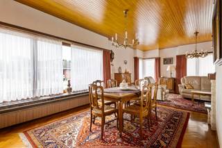 Deze gezellige woning is gelegen vlakbij het centrum van polderdorpje Berendrecht. Winkels, scholen, openbaar vervoer en ook de A12 zijn allemaal vlot bereikbaar. Hoewel de woning door de jaren heen erg goed werd onderhouden, dringt een renovatie zich aan om het geheel helemaal naar hedendaagse normen en eigen smaak in te richten. U komt de woning binnen via een inkomhal, die rechtstreeks toegang geeft tot de erg ruime, L-vormige leefruimte op mooie parketvloer. Verschillende ramen trekken hier heel wat daglicht naar binnen. Aansluitend aan de leefruimte bevindt zich de geriefelijk ingerichte leefkeuken. Verder beschikt de woning nog over een nachthal, apart toilet, badkamer met douche, kolomkast en wastafel en 2 erg ruime slaapkamers. Via een zolderluik heeft u toegang tot de bijzonder ruime zolder op de 1e verdieping. Deze doet dienst als extra opbergruimte, maar zou mits een serieuze verbouwing omgetoverd kunnen worden tot extra volwaardige ruimtes. Uw wagen kan u kwijt in de inpandige garage, maar ook op de oprit voor de woning is er ruimte om een wagen op eigen terrein te parkeren. Het perceel heeft een totale oppervlakte van 488m² en loopt rondom de woning. In het achtertuintje vindt u een super tof plekje waar u in alle rust en privacy heerlijk van de buitenlucht kan profiteren.