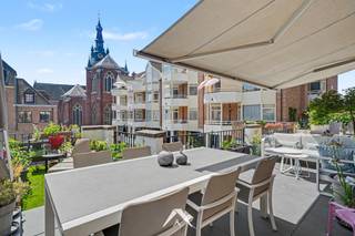 <p>In de Grote Kring, op wandelafstand van de Grote Markt, bieden wij dit volledig gerenoveerde appartement van ca 135 m² te huur aan.</p>
<p>Bij binnenkomst komt u meteen in de leefruimte met open keuken: de houten kastenwand en het keukeneiland met zwart werkblad en geïntegreerde wijnkoeler lopen naadloos over in de leefruimte met eetkamer en zithoek. De keuken sluit rechtstreeks aan op het terras van ca 30 m².</p>
<p>Verder telt het appartement 2 slaapkamers, elk met eigen badkamer, 2 toiletten en een apart bureau.</p>
<p>Via de living stapt u het dakterras op, met een elektrische zonneluifel, een zit- en eethoek en ruimte voor beplanting, met de Sint-Maartenskerk als blikvanger.</p>
<p><strong>Indeling en troeven:</strong><br />✅ Volledig gerenoveerd<br />✅ 2 slaapkamers, elk met eigen badkamer<br />✅ 2 toiletten<br />✅ Apart bureau<br />✅ Keukeneiland met zwart werkblad en geïntegreerde wijnkoeler<br />✅ Dakterras 30 m² met elektrische zonneluifel en zicht op de Sint-Maartenskerk<br />✅ Energielabel B (113 kWh/m²/jaar)<br />✅ Ondergrondse garagebox mogelijk bij te huren</p>
<p><strong>Huurvoorwaarden:</strong><br />✅ Huurprijs: € 1.550/maand<br />✅ Garagebox (optioneel): € 90/maand<br />✅ Vaste kosten: € 160/maand (€ 100 syndicus + € 60 waterverbruik, verrekend via de afrekening van de syndicus)<br />✅ Nutsvoorzieningen (gas/elektriciteit): individueel af te sluiten door de huurder<br />✅ Huurwaarborg: 3 maanden huur<br />✅ Beschikbaarheid: in overleg (vanaf 1/10/2026)<br />✅ Voorkeur voor een 3-6-9 huurovereenkomst</p>
<p><strong>Bezoekmomenten (op afspraak)</strong></p>
<p>Interesse? Contacteer ons gerust voor meer informatie of het inplannen van een bezoek.</p>