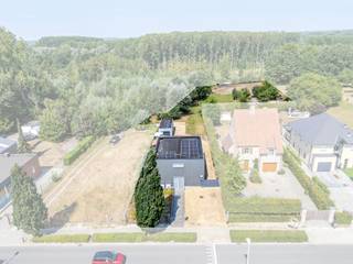 In het landelijke Letterhoutem, deelgemeente van Sint-Lievens-Houtem, bevindt zich deze vrijstaande villa met een uitgesproken industriële architectuur. De woning werd ontworpen met aandacht voor duurzaamheid én functionaliteit en staat op een indrukwekkend perceel van 5.275 m². Een bijzondere eigendom voor wie houdt van architectuur en ruimte, maar ook ideaal voor wie wonen en werken wil combineren. De open inkomhal met gastentoilet vloeit over in de indrukwekkende leefruimte met open keuken. Samen vormen ze maar liefst 135 m² aan open woonruimte. Grote raampartijen zorgen voor veel natuurlijk licht en een prachtig contact met de aangelegde tuin en het terras. De volledig ingerichte keuken beschikt over alle hedendaagse toestellen. Een bijzondere eyecatcher is de goederenlift in de leefruimte. Deze past perfect binnen de industriële architectuur en is tegelijk bijzonder praktisch om materiaal en spullen naar de verdieping te brengen. Verder bevindt zich op het gelijkvloers een zeer ruime berging en wasplaats met afzonderlijke toegang. Ook deze indeling biedt interessante mogelijkheden voor wie privé en professioneel gebruik onder één dak wil combineren. Op de eerste verdieping bevindt zich de master bedroom, momenteel ingericht op de vide en voorzien van een ensuite badkamer. Daarnaast zijn er nog twee ruime slaapkamers, een tweede badkamer en een afzonderlijke wasplaats/berging. Ook technisch werd aan comfort gedacht. De woning beschikt over 6 airco-units en twee regenwaterputten van elk 6.000 liter. Buiten zet het ruimtegevoel zich verder. De aangelegde tuin beschikt over een royaal terras en een ruime garage van 33 m². Achteraan bevindt zich een groot stuk weideland. Dankzij het totale perceel van 5.275 m² is deze eigendom dan ook bijzonder interessant voor dierenliefhebbers, hobbyisten of mensen die simpelweg dromen van veel eigen buitenruimte. Een unieke villa waar industriële architectuur, ruimte, wonen en werken op een bijzondere manier samenkomen. Interesse? Vraag uw bezoek aan via Immo Francois en ontdek ter plaatse de architectuur en mogelijkheden van deze eigendom.<br /><br />