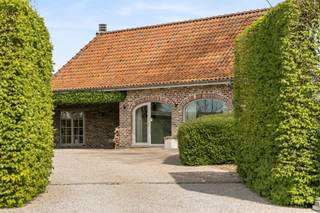 Te koop: charmante hoeve met zwembad op 3500m2 in Kruisem. Vanafprijs €998.500. In het landelijke en gegeerde Kruisem bevindt zich deze prachtige hoeve op een uitzonderlijk perceel van maar liefst 3500 vierkante meter. De eigendom, gebouwd in 1989, geniet van een volledig privatieve ligging en wordt omgeven door een mooie en ruime tuin, waardoor rust en privacy hier centraal staan.Bij het betreden van de woning ervaar je meteen het aangename ruimtegevoel en de authentieke charme. De lichtrijke leefruimtes bieden een prachtig zicht op de tuin en het zwembad, dat zonder twijfel één van de absolute troeven van deze eigendom vormt. De woning beschikt bovendien over voldoende ruimte en mogelijkheden om een vrij beroep te combineren met wonen, wat dit pand extra interessant maakt voor zelfstandigen of thuiswerkers.De uitgestrekte tuin en het ruime perceel bieden tal van mogelijkheden voor hobby’s, dierenliefhebbers of wie gewoon wil genieten van rust en natuur in alle privacy. Dankzij de gunstige ligging combineert deze hoeve landelijke rust met een vlotte bereikbaarheid.Een unieke eigendom voor wie op zoek is naar ruimte, privacy en veelzijdigheid.Interesse? Contacteer arne@immobeguin.be