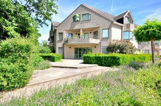 Aan de voet van het Kluisbos treffen we dit goed onderhouden appartement, op wandelafstand van de dorpskern van Ruien. Kortom, een ideale combinatie van rust en comfort.<br /><br />Dit appartement is gelegen op de tweede verdieping van een rustige residentie en is ingedeeld als volgt: we betreden het appartement via de inkomhal, aansluitend treffen we de bijzonder ruime woon- en leefruimte met geïnstalleerde open keuken en balkon. Verder is het appartement voorzien van een zeer ruime slaapkamer, technische berging, dressing en bureauhoek die tevens kan ingericht worden als bijkomende slaapkamer. De badkamer is uitgerust met een dubbele wastafel, een ligbad, een douche, aansluiting wasmachine en een apart toilet. <br /><br />Extra troef is dat er <strong>een garagebox</strong> met bergzolder is inbegrepen!<br /><br />Interesse? Contacteer Kyamo De Smet: 0479 06 13 71