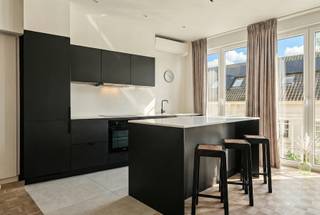 Stijlvol gerenoveerd appartement op de bovenste verdieping van een verzorgd gebouw, gelegen in het hart van het historisch centrum van Antwerpen. Dit instapklare appartement werd volledig vernieuwd in ± 2022 en combineert hedendaags comfort met kwalitatieve afwerking.
Via de inkomhal met gepantserde veiligheidsdeur betreedt u de lichtrijke leefruimte, waar een prachtige parketvloer en grote raampartijen van vloer tot plafond meteen in het oog springen. De overvloedige natuurlijke lichtinval zorgt voor een aangename en open sfeer.
Doorheen het appartement werd gekozen voor maatwerk en functionaliteit. Ingebouwde kasten bieden praktische opbergruimte, inclusief een geïntegreerde plaats voor was- en droogmachine.
De stijlvolle en open maatwerkkeuken, afgewerkt met keramische tegels en een stenen werkblad, is uitgerust met kwalitatieve toestellen (voornamelijk AEG en Samsung).
Het appartement beschikt over twee volwaardige slaapkamers en een elegante badkamer met inloopdouche, dubbele lavabo en anti-dampspiegel. Een apart gastentoilet vervolledigt het geheel.
Qua comfort en technologie werd niets aan het toeval overgelaten. Het pand beschikt over een gunstige EPC-score. De verwarming, airconditioning (warmtepomp), videofoon en domotica zijn eenvoudig via gsm aan te sturen, wat zorgt voor optimaal gebruiksgemak, het hele jaar door.
Een uitzonderlijke opportuniteit voor wie comfortabel en stijlvol wenst te wonen op een absolute toplocatie in Antwerpen.