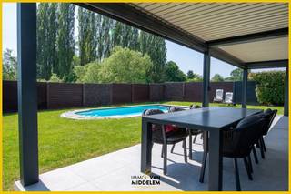 <strong>Droomt u van de ideale combinatie tussen landelijke rust en een vlotte bereikbaarheid? Immo Van Middelem stelt u graag deze ruime en lichtrijke villa (+/- 250 m²) voor, gelegen in een bijzonder rustige en groene omgeving, in een doodlopende straat nabij het centrum van Dilbeek.</strong> Deze woning is perfect voor gezinnen die op zoek zijn naar ruimte, comfort en een vleugje vakantiegevoel, terwijl scholen, winkels en openbaar vervoer zich vlakbij bevinden.<br /><br />De villa is opgedeeld in 2 niveaus: <br />- GELIJKVLOERS: inkomhal met apart toilet en vestiaire, lichtrijke leefruimte met grote raampartijen en directe toegang tot de tuin met ZWEMBAD en ruim overdekt terras, volledig ingerichte keuken met aansluitende wasplaats, inpandige garage met ruime berging; <br />- 1e VERDIEPING: ruime nachthal, bureau, 5 RUIME slaapkamers waarvan 1 met eigen badkamer alsook 2 afzonderlijke douchekamers, aparte WC;<br />- ZEER RUIME ZOLDER: 52 m², leidingen van water en elektriciteit werden reeds doorgetrokken, bereikbaar via trapladder. <br /><br />Comfort: alarmsysteem, laadpaal, alarmsysteem met camera’s; overdekt terras met ledverlichting en verwarming, verwarmd zwembad<br /><br />CV op stadsgas <br />EPC: 260 kWh/m².jaar - Label C (UC: 2201495)<br />Elektriciteit CONFORM tot 2051!<br />Asbestveilig. Vrij bij akte.
