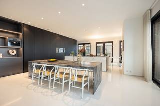 <p><b>Exclusive Penthouse Apartment with Sea Views – Entire 7th Floor</b></p>
<p>Welcome to Oosteroever, the vibrant new district of Ostend, also known as the <i>mini-Manhattan</i>. In the prestigious <b>Baelskaai 10</b> residence, you will discover an exceptional apartment where panoramic views and pure luxury come together. Completed in 2016 and designed by <b>AWG Architects</b>, this residence combines outstanding architecture, premium materials, and breathtaking views of the sea, dunes, and the Ostend skyline.</p>
<p>Upon entering, the entrance hall with separate guest toilet leads you into a bright and spacious living area, where a stunning 180° view of the city and the sea immediately captures your attention. The south-facing terrace, directly connected to the living room, allows you to enjoy a holiday atmosphere all year round. For additional comfort, the terraces are equipped with sun awnings.</p>
<p>Inside, every detail of the living space has been finished to perfection: a seamless poured floor, a built-in gas fireplace, custom-made wall cabinets, and integrated <b>Bose</b> audio. The open kitchen forms the heart of the apartment and is fully equipped with high-end appliances, including a built-in coffee machine, two refrigerators, a combi-oven, and a steam oven. Thanks to the harmoniously connected dining area and the office/hobby space, this is the perfect environment to combine living and working in style.</p>
<p>The apartment features three spacious bedrooms. The <b>master suite (28 m²)</b>, located on the east side, includes a custom-built dressing wall, an ensuite bathroom with bathtub and walk-in shower, and access to a second terrace that enjoys the morning sun. The <b>second bedroom (18 m²)</b>, located on the west side, also has its own ensuite bathroom with shower, toilet, and a sauna. From here, you have direct access to a west-facing terrace. A <b>third bedroom</b> is located at the rear of the apartment.</p>
<p>With three terraces, each offering a unique perspective – overlooking the green courtyard, the harbor, the city, and the sea – you can enjoy a different atmosphere from every angle. Practical features such as a spacious storage room and a laundry area complete this outstanding property.</p>
<p><b>Additional highlights:</b><b></b></p>
<ul>
<li><span></span>Luxurious finishes and bespoke carpentry throughout the apartment (custom-made wardrobes, natural stone, …)</li>
<li><span></span>Home automation system</li>
<li><span></span>Terraces equipped with sun awnings</li>
<li><span></span>Underfloor heating</li>
<li><span></span>Energy-efficient building with 7 floors</li>
<li><span></span>Architectural design by AWG Architects</li>
<li><span></span>Option to purchase a spacious and easily accessible underground garage box (-1)</li>
<li><span></span>Shared bicycle storage</li>
</ul>