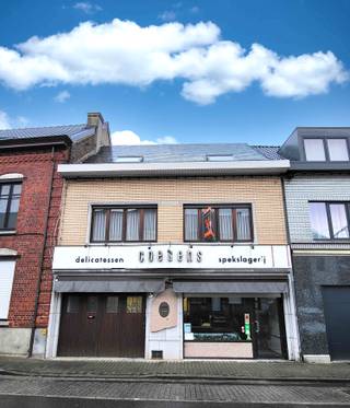 14/2 BEZOEKDAG OP AFSPRAAK BEL 0488/85.81.84 Dit veelzijdige pand met een grondoppervlakte van 240 m² combineert een ruime commerciële gelijkvloerse verdieping met een comfortabel appartement op de eerste verdieping. Het gelijkvloers deed jarenlang dienst als beenhouwerij en biedt dankzij de brede gevel van 8,1 meter en de bestaande winkel- en werkruimtes tal van mogelijkheden voor andere commerciële activiteiten zoals atelier, bakkerij, praktijk of winkel. Achter de winkelruimte bevindt zich een grote magazijn- en bakkerijzone uitgerust met professionele voorzieningen, aangevuld met een praktische bakkerijkeuken, twee toiletten, een kelder en een garage. Op de verdieping bevindt zich een ruime woonunit met een gezellige woonkamer met eiken parket en gashaardcassette, een ingerichte keuken, een badkamer met ligbad en douche, drie slaapkamers en een nachthal. Via de leefruimte is er toegang tot een zuid-oost gericht terras in bankirai. Het pand beschikt verder over een bergzolder van 27 m², centrale verwarming op aardgas met hoogrendementsketel. Met een EPC van 343 kWh/m² (label D), een renovatiejaar 1989 biedt dit gebouw een unieke kans voor wie wonen en werken wil combineren of voor investeerders die op zoek zijn naar een pand met sterke commerciële mogelijkheden. Voor een afspraak bel 0488.85.81.84