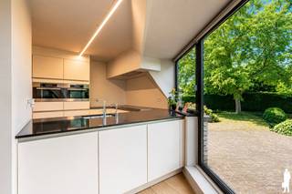 <strong>Unieke, open architectenwoning met studiovertrekken op perceel van 2.228m² gelegen in rustige Retie (nabij dorpskern) en op enkele autominuten van Postel en de Nederlandse grens (o.a. via verbindingsweg E34: Antwerpen-Eindhoven). De villa, naar doordacht-brutalistisch ontwerp en met enorm veel lichtinval, biedt o.a. 5 à 6 slpks., 4 badkamers, een buitengewoon stijlvolle natuurtuin met verschillende schaduw- en zonneterrassen en zwembad, een carport en poolhouse met keuken, douche, etc. De woning van bouwjaar 1994 is bijzonder kwaliteitsvol afgewerkt, ruim (maar liefst 473m² woonopp. excl. poolhouse) en opgedeeld in een licht leefgedeelte met salon, eettafel, een aansluitende open keuken, aparte bureauruimte, etc.; een 1e verdiep met 2 à 3 slpks., douchekamer, dressing en 2 badkamers; een 2e verdiep met andermaal 2 slpks. en een studiogeheel (met keuken, 1 slpk. en douchekamer). </strong><br /><br /><strong>De abstracte woning ademt klasse, karakter, visie en rust. De open, grote, centrale zithoek is de kern van de villa en verbindt geborgenheid van binnenin met de groene omgeving rondom de woning. De villa is gelegen aan de verbindingsweg Retie - Europese school Mol, nabij sport- en recreatiefaciliteiten (o.a. Vossekot, Nuclea golf), natuurgebied (o.a. Prinsenpark), diverse fiets- en wandelroutes en eveneens vlakbij Postel, Nederland en centrum Retie met alle voorzieningen.<br /><br />Er is een zeer gunstige EPC-score van 206kWh/m² (label C) - slechts 6 punten verwijderd van een B-label (info op aanvraag).<br /><br /></strong><em>Gelijkvloers verdiep - Inkomhal, keuken &amp; woon- en werkvertrekken</em><br /><br />Via de inkomhal met vestiaire heeft u toegang tot het woonkamer. Deze leefruimte is verdeeld in een grote zithoek, een eetruimte en een afgescheiden bureauruimte / thuiskantoor. Deze woonkamer en de aansluitende eethoek, dienst doende als centrale schakel tussen keuken en zithoek, ontvangen veel rechtstreeks daglicht door de riante raampartijen die uitgeven op de omliggende tuinomgeving. <br /><br />De keuken - met aansluitende wasplaats met douche en inbouwkasten en een afzonderlijke koele berging - bevat een kookeiland met ontbijthoek en is volledig voorzien van alle nodige kwaliteitsapparatuur: vaatwasmachine, inductiekookplaat, heteluchtoven, combi-oven, inbouwkoffiezet (allen Miele-toestellen). De keuken met prachtig verzicht over de tuin geeft verder ook uit op de afgeschermde veranda met hoge, brede raampartijen.<br /><br />In de gang is een afzonderlijke toilet voorzien. Op het gelijkvloerse gedeelte is verder een riante garage (2 staanplaatsen; sectionaalpoorten).<br /><br /><em>Bovenverdiep - niveau 1: slaapkamers, badkamers &amp; studio</em><br /><br />Op de bovenverdieping-hoofdgedeelte bevinden zich 3 ruime slaapkamers (waarvan thans 2 worden benut als slaapkamer), een badkamer en een afzonderlijke toilet. De hoofdslaapkamer heeft een eigen douchekamer en een inloopdressing. De open bovenverdieping / nachthal geeft verder toegang (thans afgesloten) tot het studiogedeelte op de bovenverdieping. Hierin is een living met leefkeuken voorzien, een slaapkamer met douchekamer en tevens een afzonderlijke toiletruimte. De villa leent zich uitermate tot kangoeroewonen.<br /><br /><em>Bovenverdiep - niveau 2: slaapkamers &amp; leisure</em><br /><br />Op de tweede verdieping zijn tevens 2 kamers voorzien; waarvan één zeer ruime kamer (nl. 33<span>m²). Eén slaapkamer dient tot slaapkamer; de andere wordt benut tot fitness, saunakamer (losstaand) en slaapkamer.</span><br /><br /><em>Buitengebeuren en kelder</em><br /><br />De woning is volledig onderkelderd (kruipkelder). Vooraan biedt de woning ruimte voor legio wagens (o.a. carport). Rondom de woning bevinden zich diverse groenstructuren met vnl. (loof)bomen, grasperken, heggen en heesters (veel winterharde beplanting). In de tuin bevinden zich verder een zwembad, poolhouse (met keuken, badkamer, zithoek, etc.) en diverse berghokken.<strong><br /></strong>