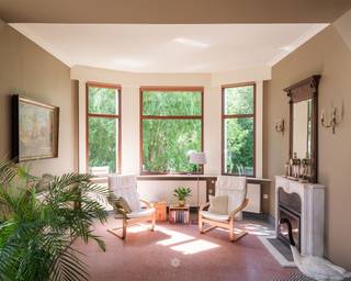 <p><span>OUDENAARDE Op zoek naar een karaktervolle herenwoning waar authentieke grandeur en hedendaags comfort elkaar ontmoeten? Dan is dit uitzonderlijke eigendom precies wat u zoekt.</span></p><p><span>Deze voormalige directeurswoning van weverij Cambier-Vandenhende ademt geschiedenis en klasse. Authentieke elementen zoals marmeren lambriseringen, boiserie, terrazzovloeren, sierhaarden en plafondrozetten werden met zorg bewaard, terwijl de woning grondig werd gerenoveerd met onder meer vernieuwde daken en ramen.</span></p><p><span>Via de imposante dubbele inkomdeur komt u in een statige inkomhal die meteen de toon zet. Aan weerszijden bevinden zich twee sfeervolle salons: de royale leefruimte met erker, open haard en toegang tot het voorterras, en een tweede salon met houthaard, ideaal als praktijk, bureau of thuiskantoor. De stijlvolle eetkamer sluit aan op de volledig uitgeruste keuken met granieten werkblad en praktische bergruimtes. Verder vindt u op het gelijkvloers een vestiaire en gastentoilet.</span></p><p><span>De woning beschikt over vijf slaapkamers, een badkamer, een ruime zolder met uitbreidingspotentieel en een volledig onderkelderd niveau met onder meer een wijnkelder. Buiten geniet u van een prachtig perceel met een zonnige tuin die volledige privacy biedt, een tuinberging en een dubbele garage met automatische poort.</span></p><p><span>Gelegen aan de rand van Oudenaarde, met scholen, winkels, openbaar vervoer en een vlotte verbinding naar de N60 vlakbij, combineert deze charmante herenwoning een prestigieuze uitstraling met een uiterst praktische ligging.</span></p>