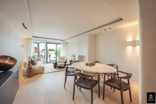 Beautifully renovated, light-filled flat with unobstructed views over the villas, within walking distance of shops and the sea. Layout: entrance hall with guest toilet. Cosy, light-filled living and dining room with a bioethanol fireplace and access to the sunny front terrace. Modern open-plan kitchen, fully equipped with high-quality appliances. Laundry room, first spacious bedroom with fitted wardrobes and an adjoining shower room. Second bedroom with fitted wardrobes and shower room (washbasin, toilet and shower). Both bedrooms open onto the rear terrace. Spacious private cellar.