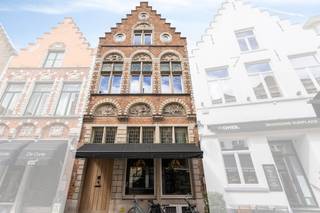 Droomt u van een eigen horecazaak op een absolute A-locatie? Dit unieke horecapand te huur in Brugge bevindt zich in de bruisende Sint-Amandsstraat, op een steenworp afstand van de historische Markt Brugge. Indeling en troeven van dit horecapand:Gelijkvloers commerciële ruimte:Een indrukwekkende en lichte ruime verbruikszaal (107m²), perfect afgewerkt met een warme parketvloer.Achteraan bevindt zich een keuken (8,5m²) niet ingericht, een functionele berging (15m²), een toilet en een koer.Het pand is volledig onderkelderd, wat zorgt voor uitzonderlijk veel opslagruimte.Eerste verdieping (woonst boven horeca):Via de overloop (20m²) bereikt u de private residentiële ruimte.Een lichte living met open keuken (36m²).Een ruime kamer (28m²).Badkamer uitgerust met douche en lavabo, plus een apart toilet.Tweede verdieping:Een ruime zolder die nog tal van inrichtingsmogelijkheden biedt.Dit pand is gelegen op een toplocatie toplocatie met een constante toestroom van lokale passanten en toeristen.