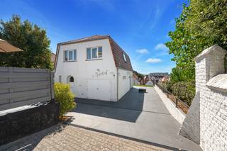 Deze charmante alleenstaande villa is uniek gelegen op het hoogste punt van het pittoreske Duinbergen, op amper 200 meter van het strand en de zee. Verscholen in een rustige en groene omgeving geniet de villa van een uitzonderlijke combinatie van privacy, een uitstekende oriëntatie en mooie vergezichten over het hinterland.<br /><br />Op het gelijkvloers bevinden zich een inkomhal met afzonderlijk toilet, een ruime en lichtrijke leefruimte met zit- en eetgedeelte, een ingerichte keuken en een garage voor één wagen. Aansluitend bevindt zich het aangename zuidgerichte terras, waar men in alle rust en discretie kan genieten.<br /><br />Op de verdieping bevinden zich vier ruime slaapkamers, elk voorzien van een lavabo, en een badkamer. Vanuit de slaapkamers geniet men van mooie uitzichten over de omgeving en een beperkt zicht op zee. Verder beschikt de woning over een zolder.<br /><br />Naast de garage is er parkeergelegenheid voor drie wagens op het perceel.<br /><br />De villa werd doorheen de jaren uitstekend onderhouden en heeft haar typische Duinbergse karakter weten te behouden.<br /><br />De ligging is zonder meer één van de belangrijkste troeven: op het hoogste punt van Duinbergen en toch op amper 200 meter van het strand, in een rustige en verscholen omgeving. Het vrijstaande karakter, de zuidgerichte buitenruimte en de grote mate van privacy maken van deze villa een bijzonder aanbod op één van de meest gegeerde locaties van Duinbergen.<br /><br />Bezoek steeds mogelijk op afspraak.