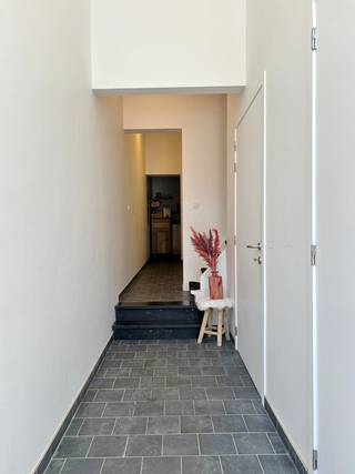 Deze ruime gerenoveerde woning bevindt zich op wandelafstand van de Grote Markt, de Leet en diverse faciliteiten zoals horecazaken en winkels. <br /><br />De gelijkvloers is als volgt ingedeeld: aparte inkomhal, bureauruimte/ruimte om zelfstandige activiteit uit te oefenen/slaapkamer, berging voor fietsen en/of vuilbakken en een apart toilet. <br /><br />Op het eerste verdiep bevindt zich de ruime lichtrijke leefruimte en de volledig geïnstalleerde keuken, met aansluitend een gezellig terras. <br /><br />Op het tweede verdiep kan de eerste slaapkamer teruggevonden worden en via een gang met ingemaakte kast kom je bij een apart toilet en een badkamer met dubbel lavabomeubel en douche.<br /><br />Het derde verdiep biedt nog een tweede ruime slaapkamer. <br /><br />- kelder aanwezig