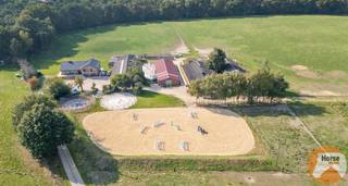 <p>OUDSBERGEN - Landbouwwoning met prachtig uitzicht en talloze mogelijkheden<br /><br />Op een absolute toplocatie, verscholen achterin en omgeven door rust en groen, bevindt zich deze stijlvolle landelijke woning met een bewoonbare oppervlakte van maar liefst 440 m². Ondanks de rustige ligging geniet u hier van een vlotte bereikbaarheid, op slechts enkele kilometers van Sentower Park en in de onmiddellijke nabijheid van fiets- en ruiterpaden.<br /><br />Deze ruime landbouwwoning uit 1978 werd in 2023 volledig gerenoveerd met oog voor kwaliteit, comfort en esthetiek.<br />Tijdens deze totaalrenovatie werden o.a. het dak vernieuwd, aluminium schrijnwerk geplaatst, zonnepanelen met batterij, airco en alarmsysteem geïnstalleerd. Binnenin werd gekozen voor een hedendaagse landelijke stijl, perfect afgestemd op de omgeving en de rustige sfeer die deze eigendom uitademt.<br /><br />De woning beschikt over een inkomhall met apart toilet, leefruimte met gashaard, eetplaats, ingerichte keuken. Vanuit eetplaats en keuken heeft men toegang tot het zeer ruim en zonnig terras met mooi weids uitzicht over eigen weiland.<br /><br />Op de verdieping treffen we 4 slaapkamers, waarvan 1 momenteel ingericht als dressing en een stijlvolle badkamer.<br /><br />Op het niveau van de garage is er een volledig ingerichte studio met eigen keuken, een zithoek, een badkamer en slaaphoek – ideaal voor inwonende familie, groom of extra slaapkamers.<br /><br />Deze studio heeft toegang tot een aparte doorgang voor en achteraan en een apart terras.<br /><br />De volledige onder keldering geeft dan weer voldoende bergruimte.<br /><br />Buiten bevinden zich hier verder 4 loodsen waarvan in de eerste loods momenteel 15 tijdelijke wedstrijdboxen met 2 wasplaatsen en 2 zadelkamers zijn ondergebracht. De tweede loods is in gebruik als opslagloods en de 3e e 4e zijn totaal te renoveren of af te breken.<br /><br />Voor de paardenliefhebbers is verder ook alles voorzien: een buitenpiste (30x50), een longeercirkel, een stapmolen alsook paddocks en aanpalende weilanden.<br /><br />Tevens is er eventueel ook meer aanpalend weiland mee te koop.<br /><br />Informeer naar de voorwaarden en contacteer ons nu voor een bezoek op 053/60 65 66!</p>