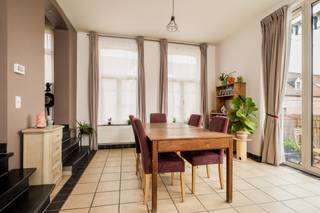 Deze herenwoning grenst aan de site 'Binnenhof' in het centrum van Hingene. Het gebouw is gerenoveerd met oog voor detail en behoud van de oorspronkelijke elementen. Het gebouw is vastgesteld bouwkundig erfgoed: Burgerhuis met bakstenen lijstgevel van vijf traveeën en twee bouwlagen onder pseudomansardedak, met oeils-de-boeuf en centraal dakvenster, vermoedelijk van circa 1912. Hierdoor geniet het gebouw specifieke vrijstellingen op energieprestatieregels. Gelegen recht tegenover de kerk van Hingene en kasteel D'Ursel is dit een ideale locatie voor mensen die van rust en privacy houden maar graag een centrale uitvalsbasis hebben naar N16 en A12. Het gebouw bestaat uit 3 appartementen, één per etage waardoor dit een standingvolle, kleinschalige residentie is. <br /><br />Indeling: Via de inkomhal kom je binnen in de ruime leefruimte (26m²) met terras. Door de zuid orientatie kan u volop genieten van de zon en zijn warmte op het terras. Via de leefruimte kan je naar een aangrenzende kamer (11m²) die gebruikt kan worden als bureau, tv-hoek, leeshoek,... . De keuken is bereikbaar via de leefruimte en beschikt over een kookplaat, oven, ijskast en vaatwasser. Achter de keuken is er een berging met aansluiting voor wasmachine en droogkast. In de inkomhal is er een afzonderlijk gastentoilet en een vestiaire. Via de hal kan je naar het slaapgedeelte. De masterbedroom is met zijn 20m² enorm ruim. Deze slaapkamer heeft een aangrenzende badkamer, met dubbele lavabo en bad. De tweede slaapkamer beschikt tevens over een eigen douche met lavabo en douche. Het volledige appartement beschikt over grote raampartijen wat er voor zorgt dat elke kamer van natuurlijk licht geniet. <br /><br />Mogelijkheid tot het aankopen van een overdekte staanplaats achteraan aan 15.000 euro. <br /><br />Het appartement is momenteel verhuurd waardoor het ook ideaal is als investering. <br /><br />Omgeving: Gesitueerd in een rustige omgeving nabij de kerk van Hingene. N16 en A12 zijn zeer toegankelijk vanaf hier. Openbaar vervoer op wandelafstand.