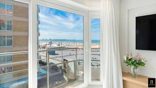 <p>Aan het iconische Rubensplein in Knokke, op een uitzonderlijke ligging op de hoek van de Zeedijk, bevindt zich dit prachtig gerenoveerde appartement met adembenemend frontaal zeezicht. Dankzij de zuidwestelijke oriëntatie geniet u hier niet alleen van een magnifiek vergezicht over zee, maar ook van zonlicht tot in de avonduren – een absolute troef.</p>
<p>De inkomhal verwelkomt u met een praktische vestiaire en gastentoilet. De hoofdslaapkamer beschikt over ruime ingemaakte kasten en sluit aan op een luxueus afgewerkte douchekamer met een tweede toilet. Ook de tweede slaapkamer is voorzien van praktische ingebouwde kasten en biedt voldoende ruimte voor een volwaardig bed of logeeropstelling.</p>
<p>De lichtrijke leefruimte baadt in het zonlicht dankzij de brede raampartijen aan de zeekant en kijkt uit over zowel het strand als het levendige Rubensplein. De open keuken vormt een stijlvol en tegelijk functioneel geheel, uitgerust met hoogwaardige Miele-toestellen, een wijnkast en een aparte diepvriezer – perfect voor wie comfort en kwaliteit weet te appreciëren.</p>
<p>Het volledige appartement werd afgewerkt met smaakvolle mortex vloeren voorzien van vloerverwarming, wat zorgt voor een strak en warm interieurgevoel.</p>
<p>Extra troeven zijn de private kelderberging en de vlot toegankelijke fietsenberging in het gebouw.</p>
<p>Een pareltje op één van de meest gegeerde locaties van Knokke, waar zeezicht, zon en elegantie samenkomen.<br />EPC: 91 kWh/m²/j [A-label]</p>