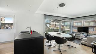 Prachtig gemeubeld gelijkvloersappartement met goed zijdelings zeezicht en privatieve tuin, uitstekend gelegen in de Paul Vandermeerschenlaan in Knokke-Heist, tussen het Casino Knokke en de Royal Belgian Sailing Club Duinbergen.<br /><br />Indeling:<br />Inkomhal met vestiaire, lichtrijke woonkamer met twee grote schuiframen die uitgeven op de zonnige tuin, volledig ingerichte keuken voorzien van alle toestellen, apart gastentoilet, twee volwaardige slaapkamers (elk geschikt voor een dubbel bed), een badkamer en een aparte douchekamer. <br /><br />Verder beschikt het appartement over een privatieve kelder in het gebouw en een tandemgaragebox.<br />De tuin wordt professioneel onderhouden.<br />Enkel te huur als tweede verblijf. Forfait aandeel syndickosten opgenomen in de prijs.<br /><br />💶 Huurprijs: €2200 per maand, inclusief tandemgaragebox in het gebouw en syndickosten.