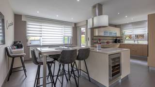 <p><strong>Ruime instapklare villa met tuin, dubbele garage en vier slaapkamers - Dilbeek</strong></p>
<p>Deze ruime, vrijstaande villa is gelegen op een perceel van 5a 18ca en biedt een praktische indeling met 4 slaapkamers, twee badkamers, dubbele garage en een lichtrijke veranda met tuin.</p>
<p>De inkomhal voorziet toegang tot de gezellige leefruimte met pelletkachel en volledig betegelde vloer. De open, moderne keuken is uitgerust met alle comfort en beschikt over een praktisch kookeiland. Op het gelijkvloers vind je bovendien een badkamer met inloopdouche en toilet, alsook een lichtrijke veranda met uitzicht op de tuin.</p>
<p>Op de bovenverdieping brengt de nachthal je naar vier ruime slaapkamers, afgewerkt met een parketvloer. De tweede badkamer is voorzien van bubbelbad, dubbele lavabo en toilet. De master bedroom beschikt over twee aansluitende dressings, wat extra comfort en bergruimte biedt.</p>
<p>In de kelder bevindt zich de technische ruimte met aansluitingen voor wasmachine en droogkast.</p>
<p>Buiten geniet je van een ruime oprit met toegang tot de dubbele garage aan de achterzijde van het perceel. Dankzij de aanwezigheid van 18 zonnepanelen is de woning bovendien uiterst energiezuinig.<br /><br />Geïnteresseerd? Plan snel uw bezoek via onze website en ontdek deze woning!</p>
<p>EPC 244 kWh/m² - label C<br />Elektrische installatie niet conform<br />Asbestveilig</p>