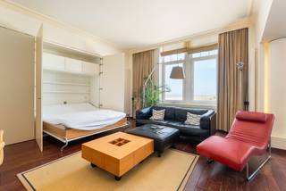 Instapklare loft-studio met adembenemend zeezicht – Residentie Palace<br />Op de eerste verdieping van het prestigieuze gebouw Residentie Palace bieden wij deze stijlvolle loft-studio te koop aan. Geniet van een subliem uitzicht op zee, duinen en de haven – een unieke locatie die rust en ruimte uitstraalt (gevel breedte van 9 meter). <br />De studio is smaakvol ingericht en omvat:<br />•Een inkomhal met ingemaakte kasten voor extra opbergruimte<br />•Grote schuifdeuren geven toegang tot de lichtrijke leefruimte met zithoek<br />•Een volledig uitgeruste open keuken voorzien van alle nodige toestellen<br />•Een moderne badkamer met douche, lavabo en toilet<br />•Apart gastentoilet <br />De volledige inrichting is inbegrepen in de prijs en bestaat uit kwalitatieve designmeubelen die perfect passen binnen de stijlvolle loft-uitstraling van de studio.<br />Daarnaast beschikt het gebouw over gemeenschappelijke voorzieningen zoals een fietsenstalling en een afvalruimte.<br />Troeven:<br />•Uitzonderlijk zicht op zee, duinen en haven<br />•Hoogwaardige afwerking en inrichting<br />•Centrale ligging in een iconisch gebouw<br />•Instapklaar<br /><br />Mogelijkheid tot aankoop van grote "wijnkelder" berging, elektriciteit en stopcontacten zijn reeds vernieuwd. De kelder heeft een oppervlakte van +/- 56m².