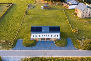 Op enkele minuten van Bastogne, in het hart van Saint-Ode, verenigt dit recente vastgoedcomplex twee geschakelde huizen met elk ongeveer 180 m² woonoppervlakte op een perceel van bijna 2.000 m². Deze configuratie biedt een interessante combinatie van residentieel erfgoed, flexibiliteit in gebruik en verhuurpotentieel.<br /><br />Elke woning biedt een ruime, lichte woonkamer, een volledig uitgeruste keuken, vier slaapkamers en twee badkamers. De leefruimtes komen uit op een terras en een eigen tuin, terwijl een garage met een gemotoriseerde deur elke eenheid completeert. De indeling maakt verschillende erfgoedstrategieën mogelijk: familiebewoning, intergenerationele co-housing of verhuur van beide woningen.<br /><br />Elk huis is voorzien van 12 zonnepanelen, hoogwaardige PVC-ramen, leistenen dakbedekking en een alarmsysteem. Verschillende apparaten zijn op afstand te bedienen. Gelegen in een residentiële en groene omgeving, blijft het complex goed bereikbaar naar Bastogne, voorzieningen en belangrijke wegen. Een zeldzame residentiële configuratie, die de koper de mogelijkheid biedt om een vastgoedportefeuille op te bouwen of te diversifiëren binnen één complex.