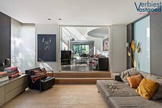 Gelegen in een rustige en gegeerde woonomgeving in Sint-Job-in-’t-Goor bevindt zich deze architecturale en lichtrijke villa, ontworpen door Ernst Architecten en gebouwd in 1996. Een woning waar ruimte, licht en kwaliteit centraal staan.<br /><br />U betreedt de woning via de inkomhal met gastentoilet en berging. De leefruimte verwelkomt u met een sfeervolle houtkachel en overvloedige lichtinval dankzij de grote raampartijen. De verlaagde zithoek creëert een gezellige en unieke woonbeleving. Aansluitend bevindt zich de open keuken met kookeiland, uitgevoerd door Bulthaup en uitgerust met hoogwaardige toestellen van Gaggenau. Op de eerste verdieping vindt u drie volwaardige slaapkamers, waaronder een master met ingemaakte kasten, twee badkamers en een lichtrijke vide die perfect dienst kan doen als bureau. De zolderverdieping van ca. 80 m² biedt tal van mogelijkheden. De tuin is een oase van rust met zon op elk moment van de dag. Verder beschikt de woning over twee opritten, een carport en voldoende parkeergelegenheid.<br /><br />Voor de volledige beschrijving en alle details: verbiestvastgoed.be<br /><br /><strong>Spreekt deze unieke villa u aan?</strong><br />Laat deze uitzonderlijke woning u dan niet ontgaan en plan vandaag nog uw bezoek ter plaatse.<br />Contacteer Verbiest Vastgoed voor een persoonlijke rondleiding.<br /><br /><strong>Denkt u eraan om te verkopen of te verhuren?</strong><br />Neem gerust contact met ons op voor een <strong><span>gratis</span></strong> en vrijblijvende waardebepaling van uw eigendom.