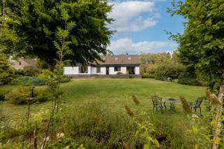 <p><strong>Deze ruime en zeer goed onderhouden villa is ideaal gelegen op een zuidgeoriënteerd perceel van ca. 1.705 m², in een rustige, groene en kindvriendelijke villawijk te Retie. De woning biedt verrassend veel ruimte en beschikt onder andere over 6 slaapkamers, 2 badkamers, een lichtrijke leefruimte en heel wat praktische bergruimte. Ook buiten is het aangenaam vertoeven dankzij de zuidgerichte tuin, het terras en de gezellige tuinkamer met open haard. De ligging vormt een bijkomende troef: bossen en talrijke fiets- en wandelroutes bevinden zich in de onmiddellijke omgeving, terwijl Retie, Postel, Dessel en Nederland op korte afstand gelegen zijn.<br /><br /></strong><span>Gelijkvloerse verdieping</span>: <span>Via de inkomhal betreedt u de woning. Rechts bevinden zich een vestiaire en een apart gastentoilet. Links geeft een deur toegang tot de ruime en lichtrijke woonkamer, die dankzij de grote raampartijen geniet van veel natuurlijk daglicht en een mooi zicht op de tuin. De leefruimte is opgedeeld in een gezellige zithoek met open haard en een eetkamer.<br /><br /></span><span>Aansluitend bevindt zich de keuken, uitgerust met een oven, elektrisch kookvuur en veel kastruimte. Naast de keuken ligt een praktische bijkeuken met ingemaakte kasten, aansluitingen voor wasapparatuur en vaatwasser en een achterdeur die rechtstreeks toegang geeft tot de tuin.<br /><br /></span><span>Via de nachthal bereikt u een eerste badkamer met douche, wastafel en toilet, een dressing en drie slaapkamers, waarvan één momenteel ingericht is als bureau en voorzien is van ingemaakte kasten. Ook één van de andere slaapkamers beschikt over ingemaakte kasten en een wastafel.<br /><br /><span>Verdieping:</span> Vanuit de inkomhal leidt de trap naar de verdieping. Hier bevinden zich nog eens drie ruime slaapkamers, waarvan twee voorzien zijn van ingemaakte kasten en een wastafel. Daarnaast is er een tweede badkamer met ligbad en douche en een apart toilet. De nachthal beschikt eveneens over praktische ingemaakte kasten. Een bijkomende troef is de bijzonder ruime opbergmogelijkheid: de schuine wanden over nagenoeg de volledige verdieping werden ingericht als bergruimte.<br /><br /><span>Buitengebeuren:</span> De woning beschikt over een aangename, zuidgerichte tuin met terras. Aansluitend aan de woning bevindt zich een gezellige tuinkamer / overdekt terras met open haard, waardoor u ook tijdens koelere momenten optimaal van de tuin kunt genieten. De tuin is achteraan volledig omheind en biedt veel rust en privacy.<br /><br />Naast de tuinkamer bevindt zich nog een praktische berging met spoelbak en technische ruimte. Aan de woning is tevens een overdekte carport voorzien, met in het verlengde een royale fietsenberging/werkplaats die heel wat extra praktische ruimte biedt. Vooraan beschikt de woning over een oprit met ruime parkeergelegenheid.<br /><br /><span>Bijzonderheden:</span> <br />- B</span>ouwjaar: 1988<br />- Centrale verwarming op aardgas via radiatoren<br />- Veluxramen voorzien van rolluiken<br />- Houten schrijnwerk<br />- Vliegenramen<br />- Kruipruimte onder de volledige woning<br />- Veel ingemaakte kasten en bergruimte<br />- Overdekte carport<br />- Rustige en kindvriendelijke villawijk<br />- Groene ligging nabij bossen en diverse fiets- en wandelroutes<br /><br /><span>Bekijk dit eigendom via onze interactieve grondplannen: https://visithome.ai/fM2Mc7ERqp5AmkVDRGaPFt?mu=m</span></p>