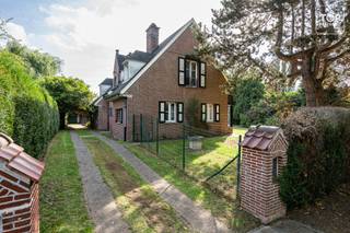 <p>In een bijzonder residentiële en groene straat, omgeven door hoogstammige bomen en verschillende kasteeldomeinen, bevindt zich deze karaktervolle villa op een zuidgericht perceel van meer dan 900 m².<br /><br />De locatie biedt een uitzonderlijk goede MOBI-score en combineert een rustige woonomgeving met een bijzonder uitgebreid aanbod aan voorzieningen. Aan de overzijde van de straat bevindt zich een apotheek. Verderop in de straat vindt u zowel Colruyt als Delhaize (open tot 20 uur, ook op zondag), een tankstation, kleinhandel en horeca. Meerdere scholen liggen op wandelafstand, terwijl de op- en afrit van de R4 op amper 2 minuten rijden bereikbaar is. Met de fiets staat u bovendien in ongeveer 12 minuten in het centrum van Gent.<br /><br />De villa beschikt over maar liefst drie slaapkamers alle drie op de verdieping op het gelijkvloers beschik je nog over 2 aparte ruimtes die je zelf nog volledig kan inrichten. De leefruimte wordt gekenmerkt door een mooie parketvloer en sluit aan op een bijzonder lichtrijke veranda, vanwaar u een aangenaam contact heeft met de tuin.<br /><br />Zowel de tuin als het zwembad zijn optimaal zuidgericht, waardoor u hier maximaal van de zon en het buitenleven kunt genieten.<br /><br />Ook praktisch heeft deze woning heel wat te bieden. Zo is er een ruime dubbele garage die aan de binnenzijde niet door een tussenwand wordt opgedeeld. Hierdoor ontstaat één grote open ruimte die niet alleen geschikt is voor meerdere wagens, maar eveneens perfect dienst kan doen als atelier of hobbyruimte.<br /><br />Een bijkomende troef is dat al het buitenschrijnwerk recent werd vernieuwd.<br /><br />De villa is aan renovatie toe, maar vormt dankzij haar karakter, royale perceel, vijf slaapkamers, zuidgerichte tuin met zwembad, lichtrijke veranda en bijzonder ruime garage een uitstekende basis voor wie een karaktervolle woning naar eigen smaak wil afwerken.<br /><br />Een eigendom die rust en groen combineert met een uitstekende bereikbaarheid en de nabijheid van alle dagelijkse voorzieningen.<br /><br />Het perceel van de villa en het aanpalende bouwperceel dienen na afloop van de biedingsronde en de toewijzing aan de uiteindelijke koper nog officieel te worden opgesplitst alvorens de notariële akte kan worden verleden. De verkoop gebeurt bijgevolg via een aankoop-verkoopbelofte, onder de opschortende voorwaarde van de opsplitsing van beide percelen.</p>