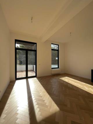 <p>Dit appartement is gelegen in een recent gerenoveerd gebouw dat is opgenomen in de lijst van beschermd erfgoed vanwege zijn prachtige neoclassicistische stijl. De charme van deze historische stijl blijft behouden, gecombineerd met moderne hoogwaardige afwerking.<br />Het is gesitueerd op de eerste verdieping en bereikbaar via lift. Bij binnenkomst wordt de ruimte overgoten met natuurlijk licht, waardoor een warme en uitnodigende sfeer ontstaat. Hoge plafonds, warme parketvloeren en elegante binnendeuren geven dit appartement zijn unieke karakter. Het woongedeelte aan de achterkant sluit naadloos aan op een terras met vrij uitzicht op een groene oase. De open keuken is voorzien van hoogwaardige Siemens apparatuur.<br />Het appartement beschikt over een apart toilet met wastafel. De hoofdslaapkamer met aangrenzende dressing en moderne badkamer heeft ook een eigen terras, met behoud van de karakteristieke neoclassicistische terrasleuning.<br />Daarnaast biedt het appartement een aparte berging met aansluitingen voor wasmachine en droger, evenals een extra ondergrondse berging. De nutsvoorzieningen voor gas, elektriciteit en water zijn individueel afsluitbaar.<br />Dit appartement heeft een uitstekende locatie in een centrale buurt, dicht bij het historische centrum en het Harmoniepark, met snelle toegang tot belangrijke uitvalswegen en snelwegen.</p><p>Wordt U huurder van dit prachtige pand?</p>