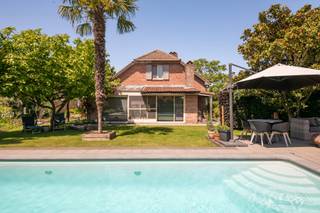 Kwalitatief gerenoveerde villa in tijdloze stijl op een residentiële locatie in Stabroek.<br /><br />We betreden de woning via de inkomhal, die is voorzien van een gastentoilet met handenwasser.<br /><br />De sfeervolle L-vormige leefruimte op kurkvloer, is ingedeeld in een gezellige zithoek met houtkachel en een eetkamer. Aansluitend werd een mooie veranda aangebouwd, die zorgt voor extra leefruimte en lichtinval.<br /><br />De gerenoveerde keuken in landelijke stijl is volledig uitgerust met een Boretti-kookfornuis met oven, een microgolf, spoelbak, vaatwasser en een koelkast.<br /><br />Op het gelijkvloers vinden we verder een slaapkamer en een vernieuwde badkamer, voorzien van een douche en een dubbele lavabo.<br /><br />Tot slot beschikt de woning op het gelijkvloers over een gerenoveerde garage met ingemaakte kasten en een praktische berging met aansluitingen voor wasmachine en droogkast.<br /><br />Op de eerste verdieping komen we uit op een ruime kantoorruimte, ideaal als thuiswerkplek of hobbyruimte. Vanuit het kantoor is er een prachtig zicht op de omliggende weilanden.<br /><br />De nachthal geeft toegang tot drie slaapkamers, waarvan één is voorzien van een sauna.<br /><br />De tweede badkamer beschikt over een inloopdouche en een enkele lavabo.<br /><br />Daarnaast bevinden zich op de nachthal nog een apart nachttoilet en een extra berging, wat zorgt voor extra comfort en extra opbergruimte.<br /><br />De rustgevende tuin heeft een gunstige oriëntatie op het zuidoosten en werd zorgvuldig aangelegd met mooie beplanting en een verwarmd zwembad (8 m x 4m) met automatische chloor- en pH-regeling. Voorts bevindt er zich nog een poolhouse.<br /><br />Vooraan bevindt zich een carport voor één wagen, er is tevens voldoende parkeerplaats op eigen grond.<br /><br />Algemeen:<br /><br />- Mogelijkheid tot gelijkvloers wonen.<br />- Luxevoorzieningen.<br />- EPC B.<br />- Elektriciteit conform.<br />- Residentiële locatie.<br /><br />Deze gezinswoning is gelegen in een rustige en residentiële buurt in Stabroek met enkel bestemmingsverkeer. Een zeer gegeerde locatie!<br />Alle voorzieningen zoals winkels, scholen en openbaar vervoer bevinden zich in de directe nabijheid.<br />De oprit van de autosnelweg is vlakbij met een goede verbinding naar Antwerpen, Nederland en de haven!