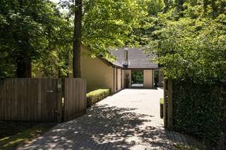 <strong>Moderne villa met orangerie, paardenstallen en volledige privacy, op een mooi en groen perceel van ca. 2.565 m²</strong><br /><br /><strong>De gelijkvloerse verdieping:</strong><br />- een <strong>inkomhal </strong>op natuursteen met gastentoilet en handenwasser,<br />- een lichtrijke <strong>woonkamer </strong>met <strong>gashaard</strong>, grote raampartijen en openslaande deuren naar de tuin,<br />- een aangename <strong>orangerie</strong>/<strong>familyroom</strong>, afgewerkt met keramische tegelvloer, voorzien van schuiframen, airconditioning en directe toegang tot het terras, <br />- een <strong>keuken </strong>met dubbele spoelbak en Siemens-inbouwtoestellen, waaronder een vaatwasser, gasvuur, microgolfoven en heteluchtoven,<br />- een praktische <strong>wasplaats </strong>met aansluitingen voor wasapparatuur en een tweede inkom,<br />- een open <strong>vide</strong> boven de woonkamer, momenteel ingericht als <strong>bureauruimte</strong>,<br />- een ruime <strong>slaapkamer </strong>met ingemaakte kasten en toegang tot het terras,<br />- een aansluitende <strong>dressing</strong> met maatkasten, mogelijkheid tot extra slaapkamer<br />- een <strong>badkamer</strong> uitgerust met ligbad, douche, dubbele lavabo en toilet.<br /><strong><br />De verdieping:</strong><br />- middels <strong>trap </strong>naar de verdieping<br />- <strong>twee ingerichte kamers</strong> en beschikken elk over een eigen wastafel<br />- een <strong>gedeelde douchekamer</strong> met douche en toilet,<br /><strong> <br />De tuin:</strong><br />- een fraai aangelegde<strong> tuin</strong> met volledige <strong>privacy</strong>,<br />- meerdere <strong>zonneterrassen</strong>, <br />- een sfeervolle <strong>vijver </strong>als blikvanger,<br />- <strong>paardenstallen </strong>achteraan het perceel, mogelijk ook als werkatelier in te richten,<br />- een <strong>achteringang </strong>met rechtstreekse toegang tot de stallen en de carport,<br />- een praktische <strong>tuinberging</strong>. <br /><strong><br />Algemeen:</strong><br />- <strong>houtskeletbouw</strong> met warme en duurzame uitstraling,<br />- zeer <strong>lichtrijke </strong>woning dankzij de open vide en grote glaspartijen,<br />- nieuwe cv-ketel (Vaillant) geplaatst in 2023,<br />- orangerie/veranda gerealiseerd in 2014,<br />- <strong>warmtepomp </strong>aanwezig,<br />- <strong>rustige ligging </strong>met optimale <strong>privacy</strong> op het volledige perceel<br />- stedenbouwkundige inlichtingen in aanvraag