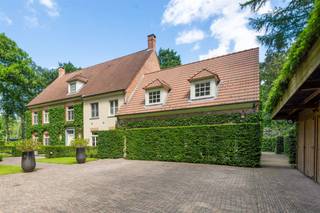 <p><span>Deze zeer ruime villa is gelegen op een discrete en rustige locatie nabij natuurgebied De Uitlegger.</span></p><p><span>Met een perceel van ca. 7.000 m² geniet u van de natuur en privacy op uw eigen terrein. </span></p><p><span>Deze villa werd gebouwd in 2001 en voldoet aan de hedendaagse normen van comfort. </span></p><p><span> </span></p><p><span>Indeling</span></p><p><span>U betreedt de villa middels de centrale inkomhal met gastentoilet, vestiaire en trap naar de verdieping. Vanuit de inkomhal toegang tot de royale living en het bureel. De living bestaat uit een ruime woonkamer en aansluitende eetkamer, beiden met mooi uitzicht over de tuin. Aan de voorzijde van de woning bevindt zich een ruim bureel. De zeer ruime woonkeuken heeft dankzij een veranda meer dan voldoende ruimte voor het plaatsen van een grote eetkamertafel. </span></p><p><span>Vanuit de keuken toegang tot de bijkeuken/wasplaats en aansluitend de inpandige garages welke momenteel zijn ingericht als wellness en fitness.</span></p><p><span> </span></p><p><span>Verdieping</span></p><p><span>De nachthal geeft u toegang tot een gigantische masterbedroom bestaande uit een royale slaapkamer, dito dressingkamer en een privatieve badkamer. Nog twee ruime slaapkamers, een tweede badkamer en een waskamer of linnenkamer. </span></p><p><span> </span></p><p><span>2e verdieping</span></p><p><span>Middels de vaste trap bereikt u de volledig ingerichte tweede verdieping met nog twee slaapkamers en een bijbehorende badkamer. </span></p><p><span> </span></p><p><span>Parkeren</span></p><p><span>De inpandige garage biedt ruimte voor drie wagens, doch is momenteel ingericht als bijkomende leefruimte met wellness en fitness. Tevens is er een ruime carport voor meerdere auto's, met twee open staanplaatsen en twee afsluitbare parkings.</span></p><p><span> </span></p><p><span>Tuin en buitenruimtes</span></p><p><span>Dankzij de aangelegde tuin met volwassen beplanting geniet u van alle rust en privacy. De tuin beschikt over ruime terrassen, een verwarmd zwembad, poolhouse etc.</span></p><p><span> </span></p><p><span>Bijzonderheden</span></p><p><span>Deze villa werd met veel zorg gebouwd en onderhouden. Een prachtig eigendom met vele mogelijkheden.</span></p><p><span>Het eigendom is gelegen op een residentiële locatie met nabij gelegen natuurgebied "De Uitlegger". </span></p><p><span> </span></p><p><span>Meer info via ons kantoor.</span></p>