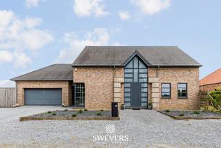 Voor meer info en foto’s, surf naar www.swevers.be – Welkom aan de Papeheide 29 in Kortessem, waar deze ruime en instapklare open bebouwing comfort, ruimte en functionaliteit mooi combineert. Met een bewoonbare oppervlakte van 311 m² op een perceel van 8a 36ca is dit de ideale thuis voor wie royaal wil wonen én werken. De lichtrijke leefruimte van ruim 39 m² vormt het gezellige hart van de woning en sluit aan op de volledig uitgeruste leefkeuken van bijna 27 m². Deze werd in 2016 vernieuwd en beschikt over kwalitatieve Neff-toestellen, een ingebouwd koffietoestel en een Amerikaanse koelkast. Grote raampartijen zorgen voor veel natuurlijk licht en een fijne connectie met de tuin. Een extra troef is de multifunctionele praktijkruimte van ca. 18 m², momenteel ingericht als kapsalon, maar ook perfect bruikbaar als thuisbureau, hobbykamer of praktijk. Dankzij de ruime parkeermogelijkheden vooraan ontvangt u bezoekers of klanten met gemak. Op de verdieping vindt u vier volwaardige slaapkamers van ca. 18 tot 21 m², ideaal voor een groot gezin, gasten, bureau- of dressingruimte. Verder zijn er een praktische badkamer, een zolder van 18,40 m² en een volledig onderkelderde kruipkelder met veel bergruimte. Ook technisch zit het goed: conforme elektriciteit, thermisch aluminium schrijnwerk met hoogrendementsglas, EPC-label C, alarm, brandalarm en een regenwaterput aangesloten op toiletten en wasplaats. De dubbele inpandige garage, carport en tuinberging bieden extra comfort. Met scholen, winkels, openbaar vervoer en de autosnelweg vlakbij geniet u hier van een vlotte ligging nabij Kortessem en Hasselt. Voor meer informatie, bel 011 255 155. Bron bewoonbare oppervlakte: EPC – verslag.